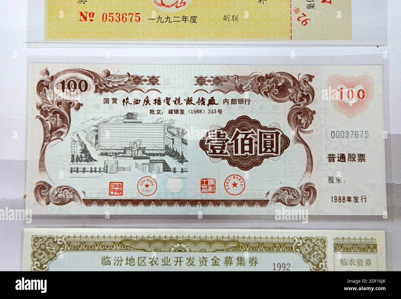 Aktien (glaube ich) aus dem Jahr 1988, die auf einem Antiquitätenmarkt im Westen von Peking, China, ausgestellt wurden Stockfoto