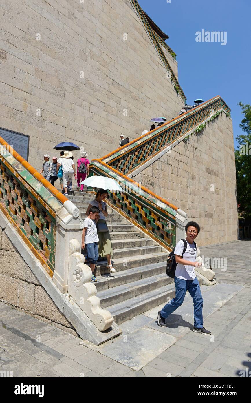 Besucher steigen einen Treppenflug durch kaiserliche gelbe Fliesen am Sommerpalast in Peking, China Stockfoto