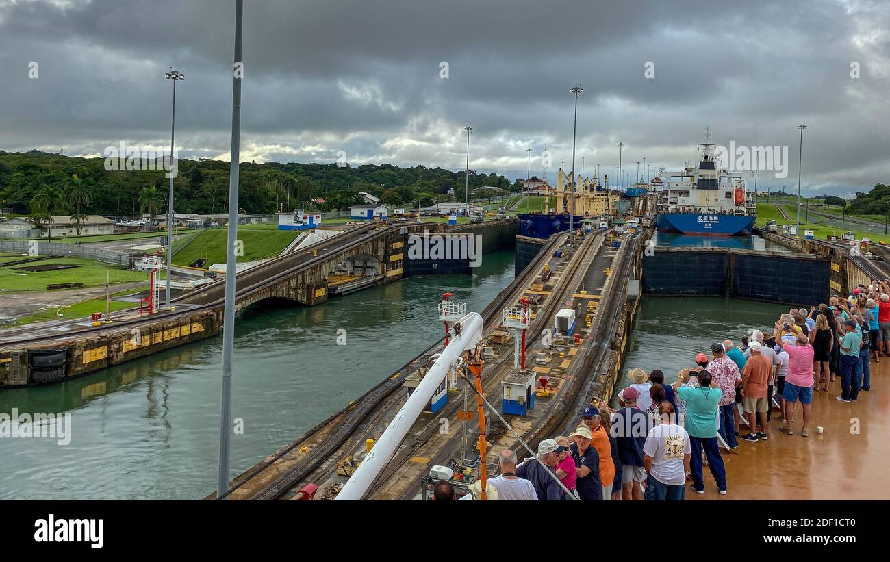 Panama - 11/6/19: ein Kreuzfahrtschiff mit den Passagieren auf dem Bug des Schiffes beobachten die erste Schleuse des Panamakanals eingeben. Stockfoto