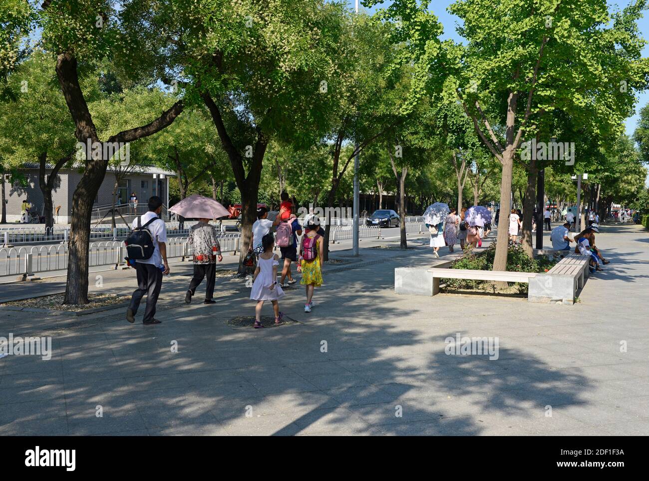 Touristen gehen nach ihrem Besuch eine Straße vor dem Sommerpalast im Nordwesten von Peking entlang. Peking, China. Stockfoto