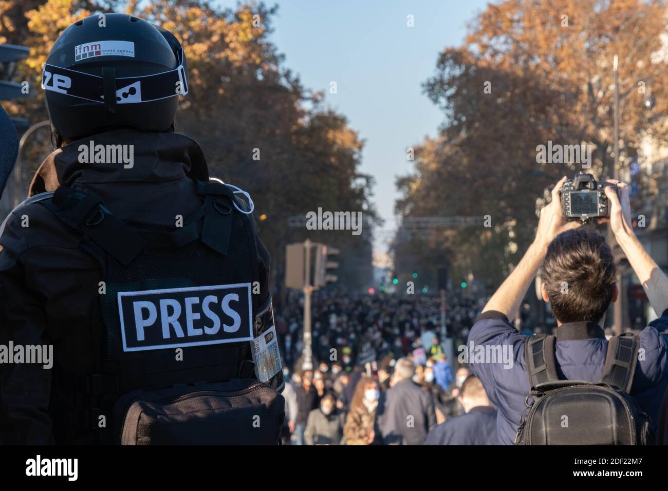 Paris, Frankreich - 28. November 2020 : auf dem marsch gegen das globale Sicherheitsgesetz beobachtete ein Journalist mit Helm die riesige Menschenmenge, die hereinkam Stockfoto