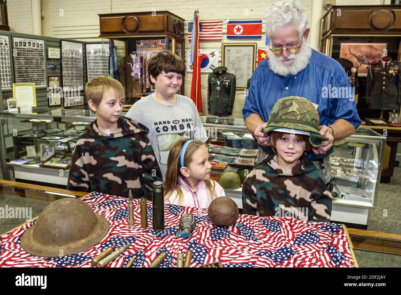 Alabama Athen Alabama Veteran's Museum & Archive, Ausstellungen Sammlung Helme Munitionsschalen, Jungen Mädchen Kinder Kinder, schauen Mann Führer explai Stockfoto