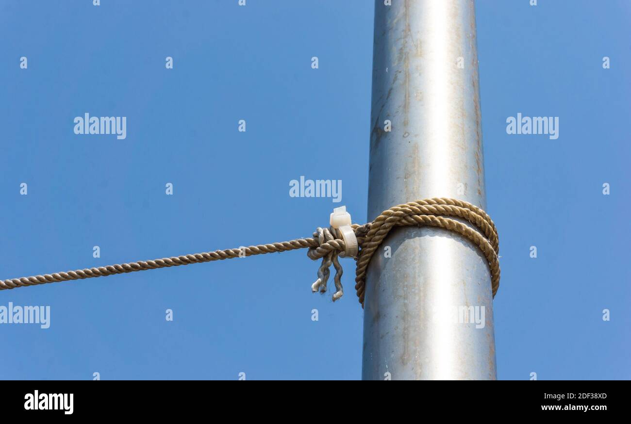 Ein Metallmast und geknüpfte Knoten mit einem blauen Himmel Stockfoto