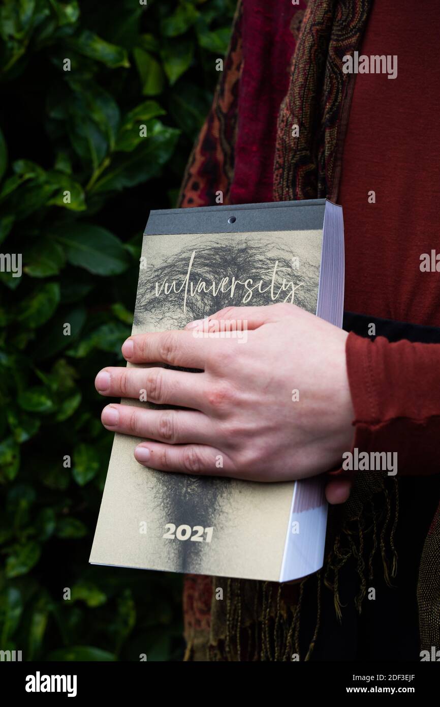 Freiburg, Deutschland. November 2020. Ein Mitglied des Freiburger Kollektivs Vulvaversity hält einen ihrer Kalender in der Hand und deckt Teile davon ab. Das Freiburger Kollektiv Vulvaversity hat einen Kalender für 2021 mit 365 Vulvaren veröffentlicht. Das Projekt soll dazu beitragen, Scham und Vorurteile zu reduzieren. (To dpa: '365 Vulves - Freiburg Group publishs enlightening calendar') Quelle: Philipp von Ditfurth/dpa/Alamy Live News Stockfoto
