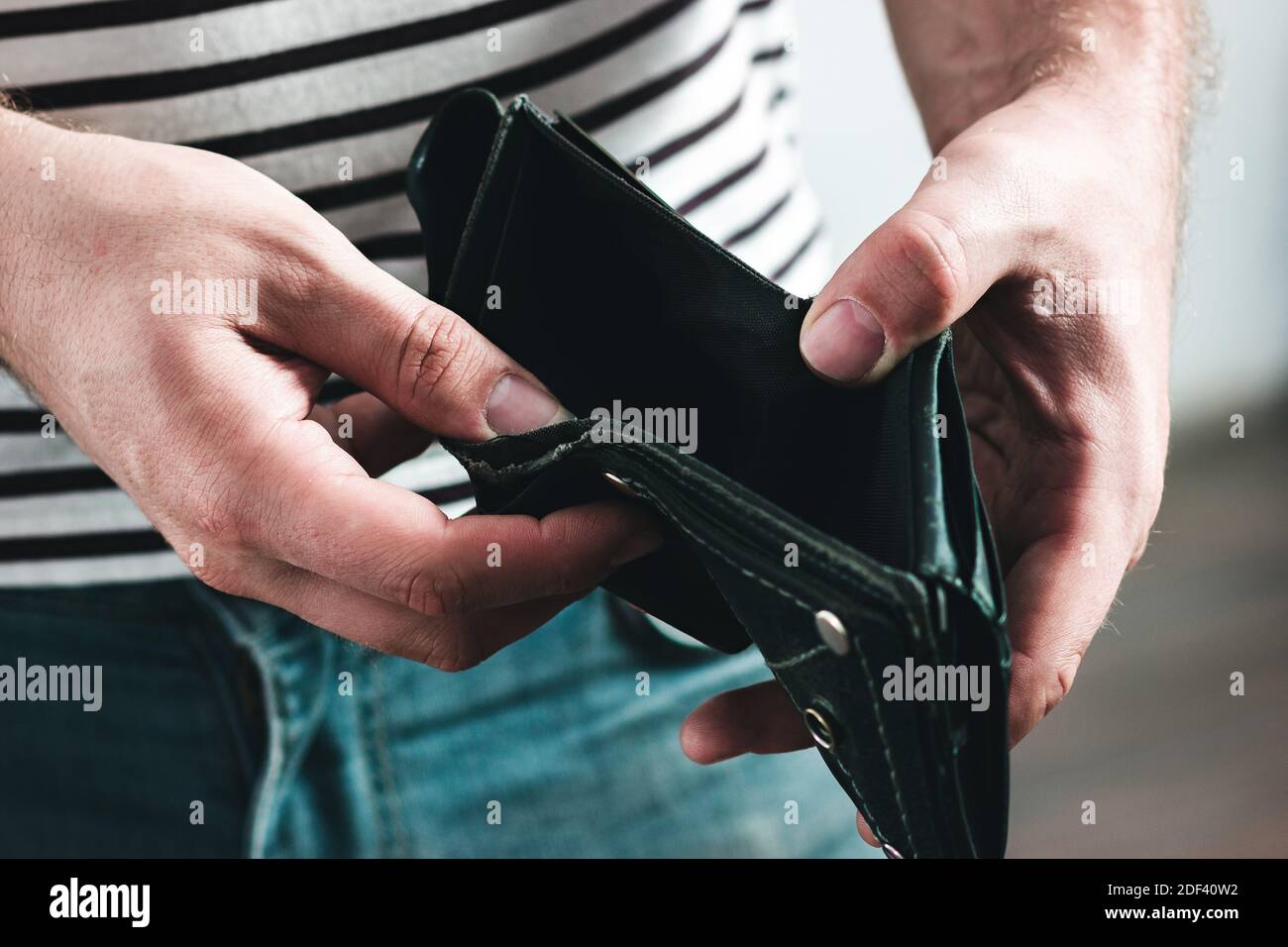 Leere Brieftasche in männlichen Händen als Symbol Finanzkrise und schlechte Wirtschaft. Stockfoto