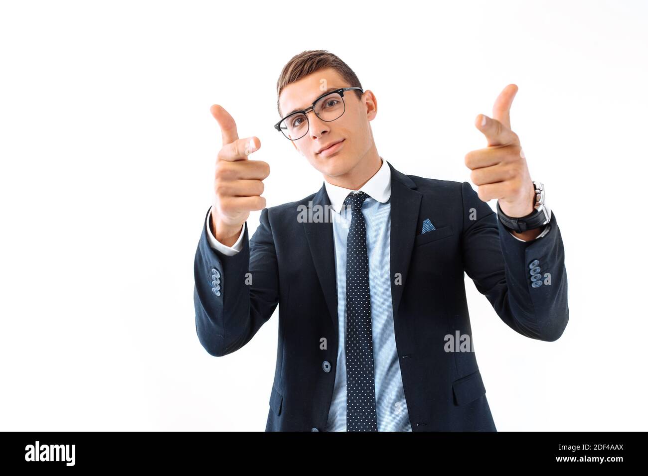 Erfolgreicher Geschäftsmann in Brille und Anzug, fröhlich lächelnd, zeigt die Finger auf die Kamera, versuchen, Ihre Aufmerksamkeit zu bekommen. Stockfoto