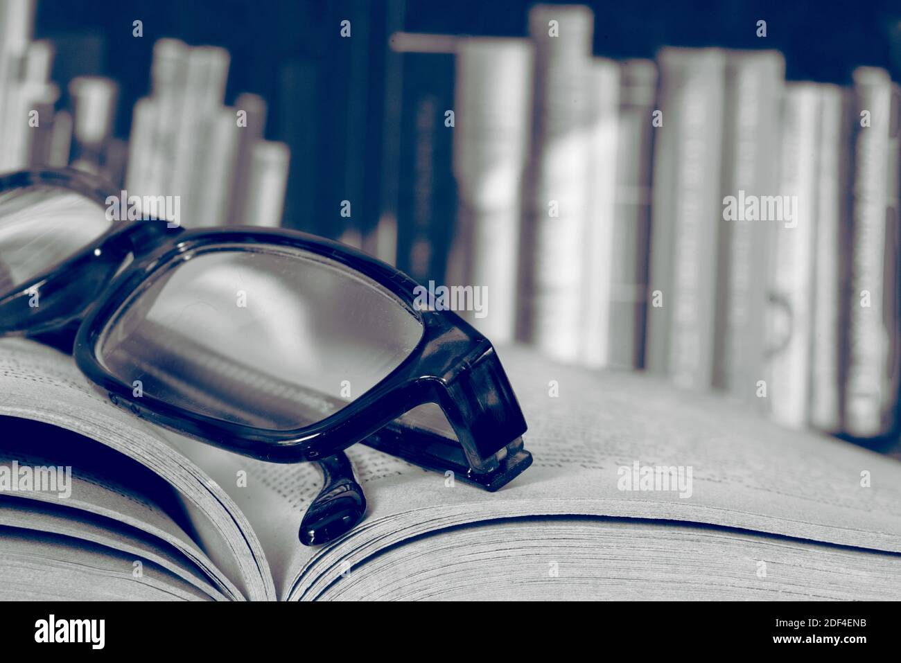 Eine Brille, ein Buch und die Bibliothek Stockfoto