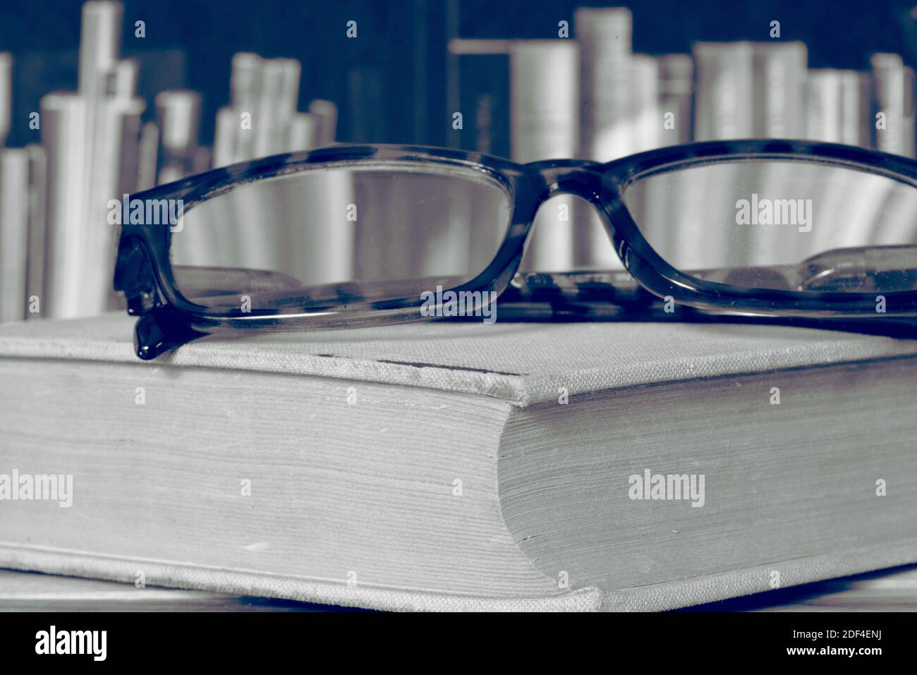 Eine Brille, ein Buch und die Bibliothek Stockfoto