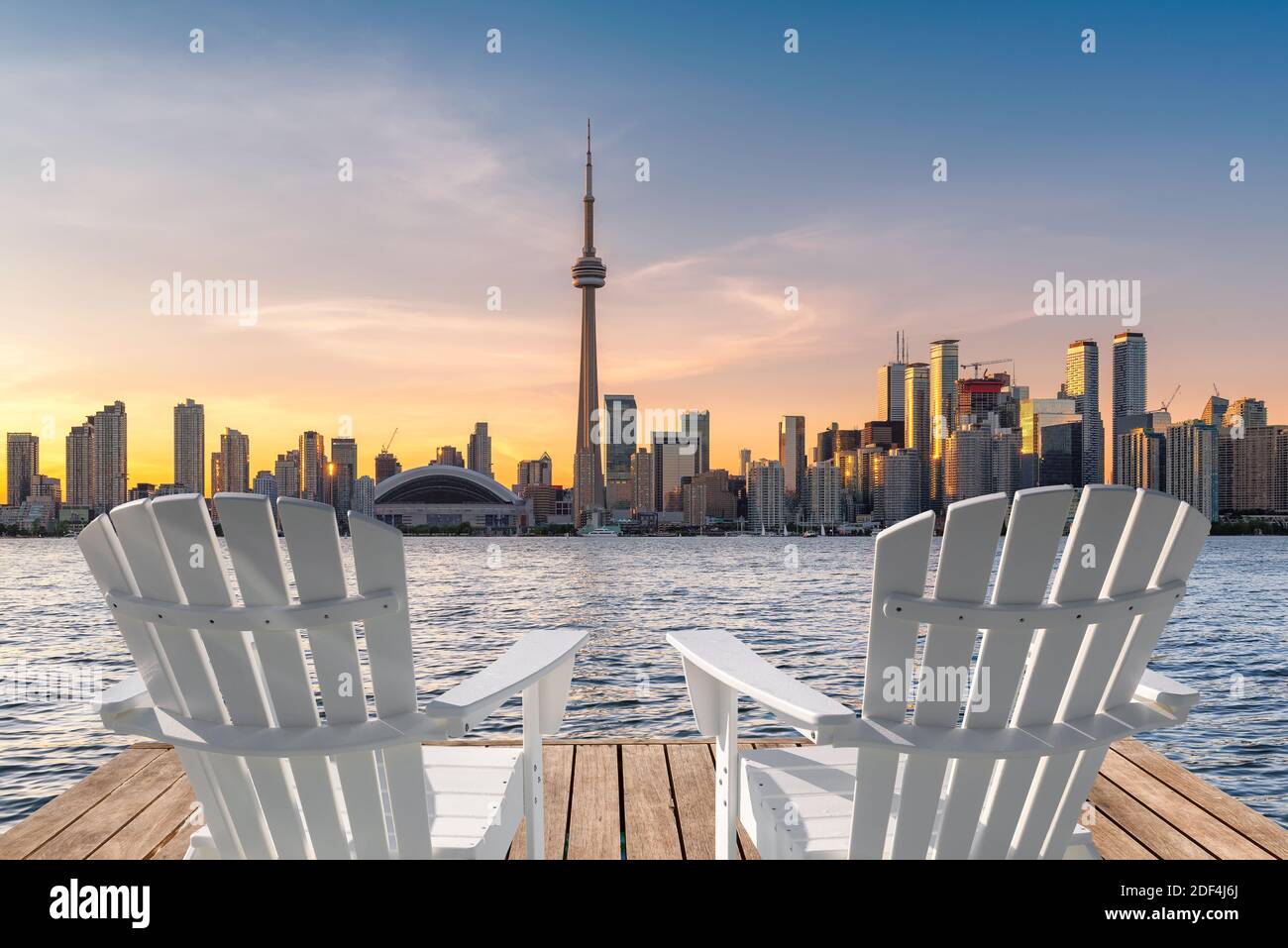 Toronto Skyline in hölzernen Pier mit weißen Stühlen bei Sonnenuntergang in Toronto, Ontario, Kanada. Stockfoto