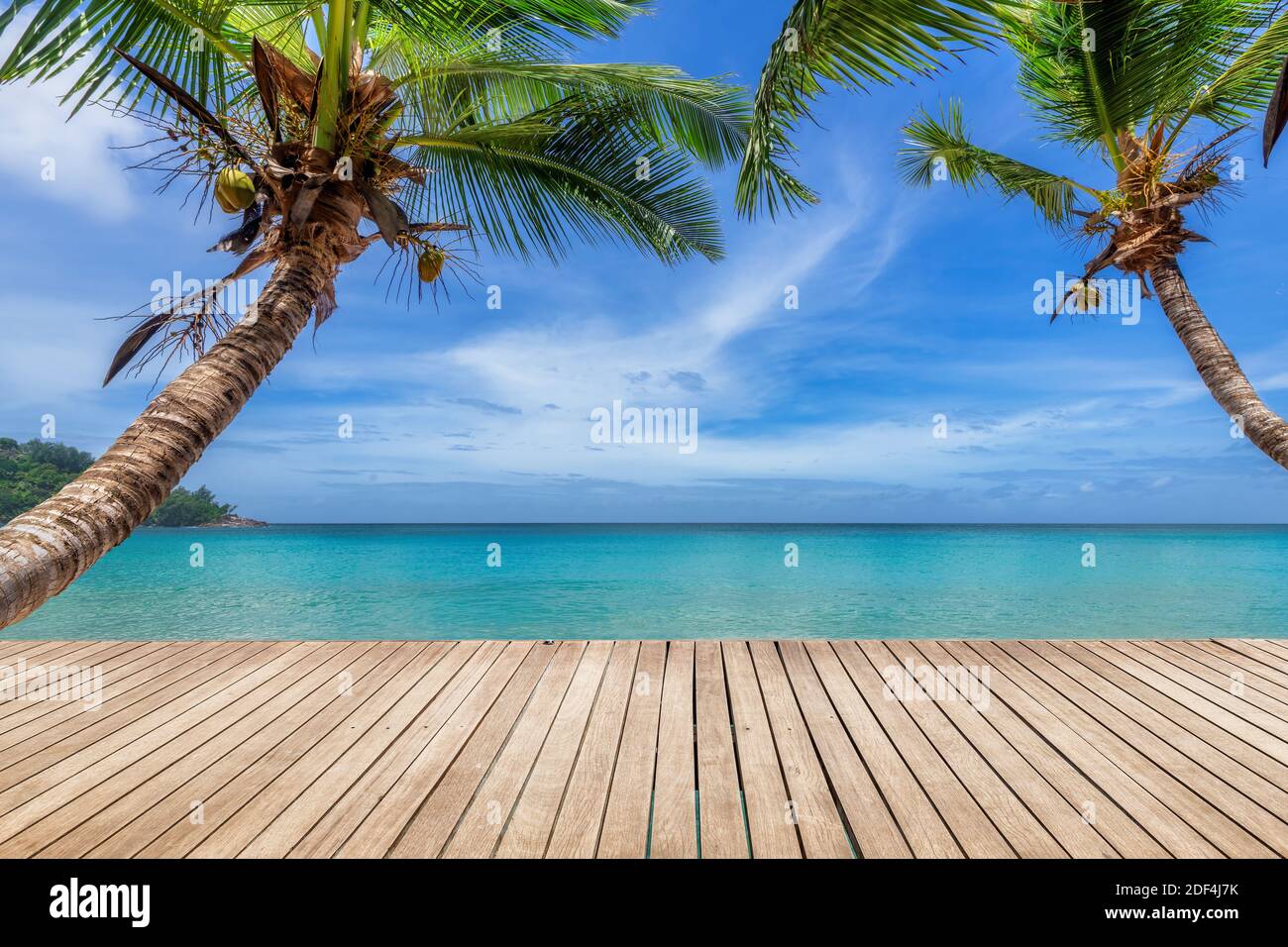 Tropischer Sonnenstrand mit Holzboden, Palmen und dem türkisfarbenen Meer auf Paradise Island. Stockfoto