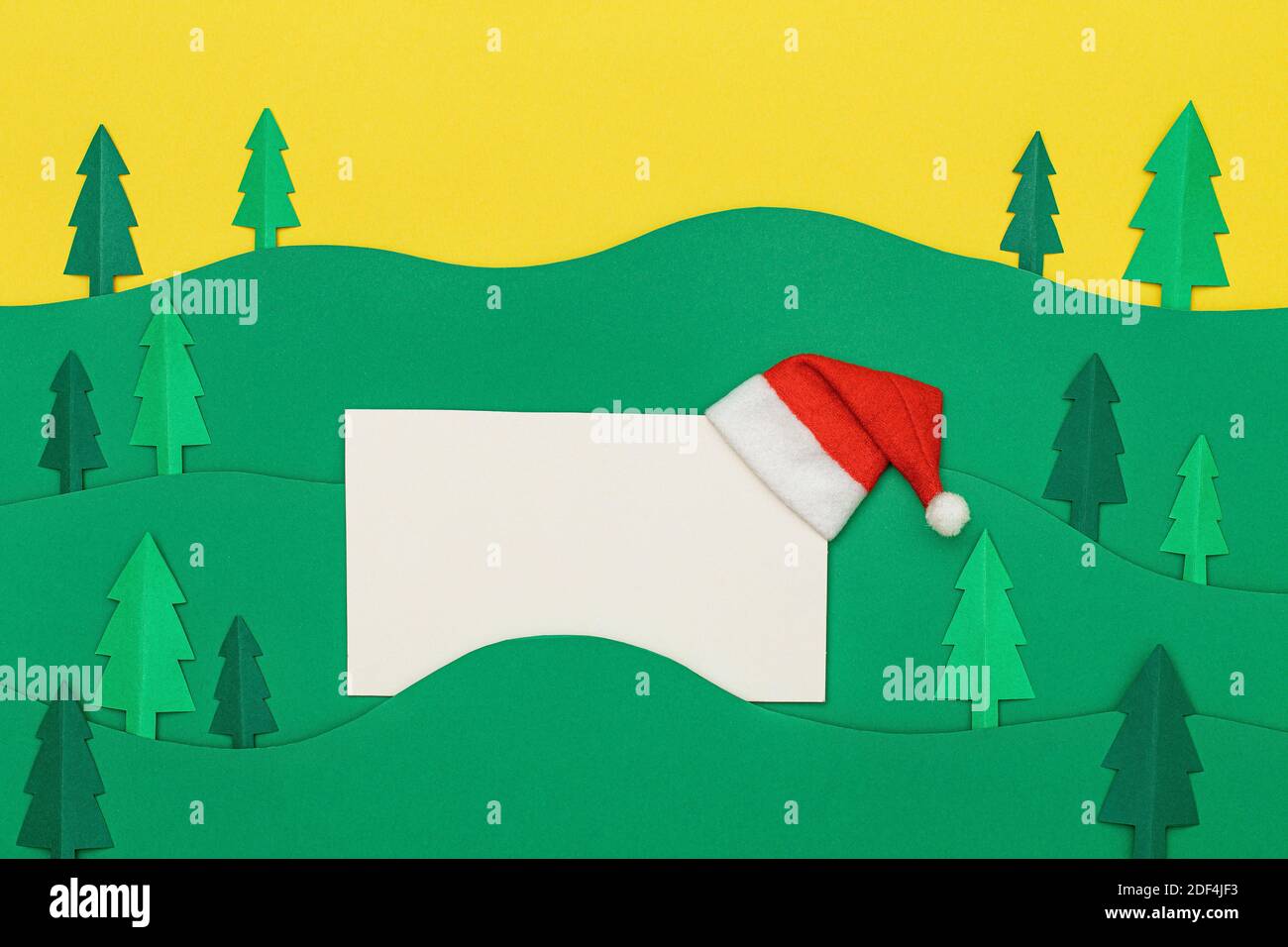 Weihnachtsbaum Papier schneiden Design papercraft Karte mit Weihnachtsmann Hut. Papiergeschnittene Weihnachtsbäume. Kreative Gestaltung von weihnachten Hintergrund mit pape Stockfoto