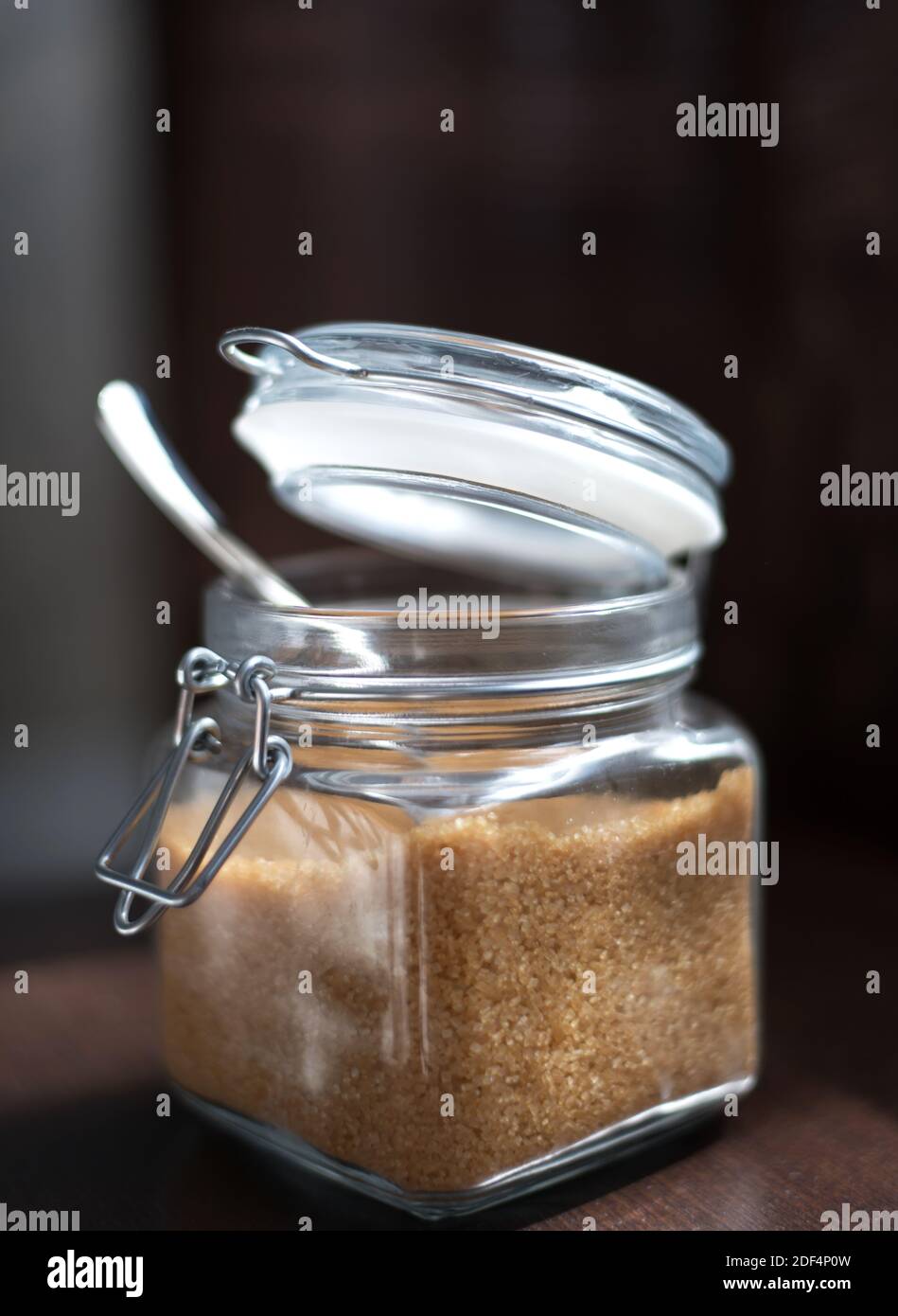 Transparentes Glas mit braunem Zuckerrohr auf schwarzem Hintergrund. Stockfoto