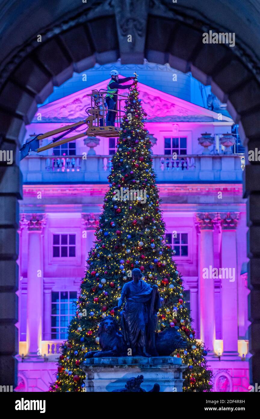 London, Großbritannien. Dezember 2020. Somerset House fügt die endgültige Dekoration zu seinem 40 Fuß Weihnachtsbaum vor der Wiedereröffnung, nach dem Ende der zweiten Coronavirus-Sperre, am Donnerstag, 3. Dezember. Neben dem Baum können die Besucher des Londoner Kunstgewerbezentrums im neoklassizistischen Innenhof Pop-up-private Dining-Kuppeln nutzen und so ein neues festliches Gourmet-Erlebnis schaffen. Kredit: Guy Bell/Alamy Live Nachrichten Stockfoto