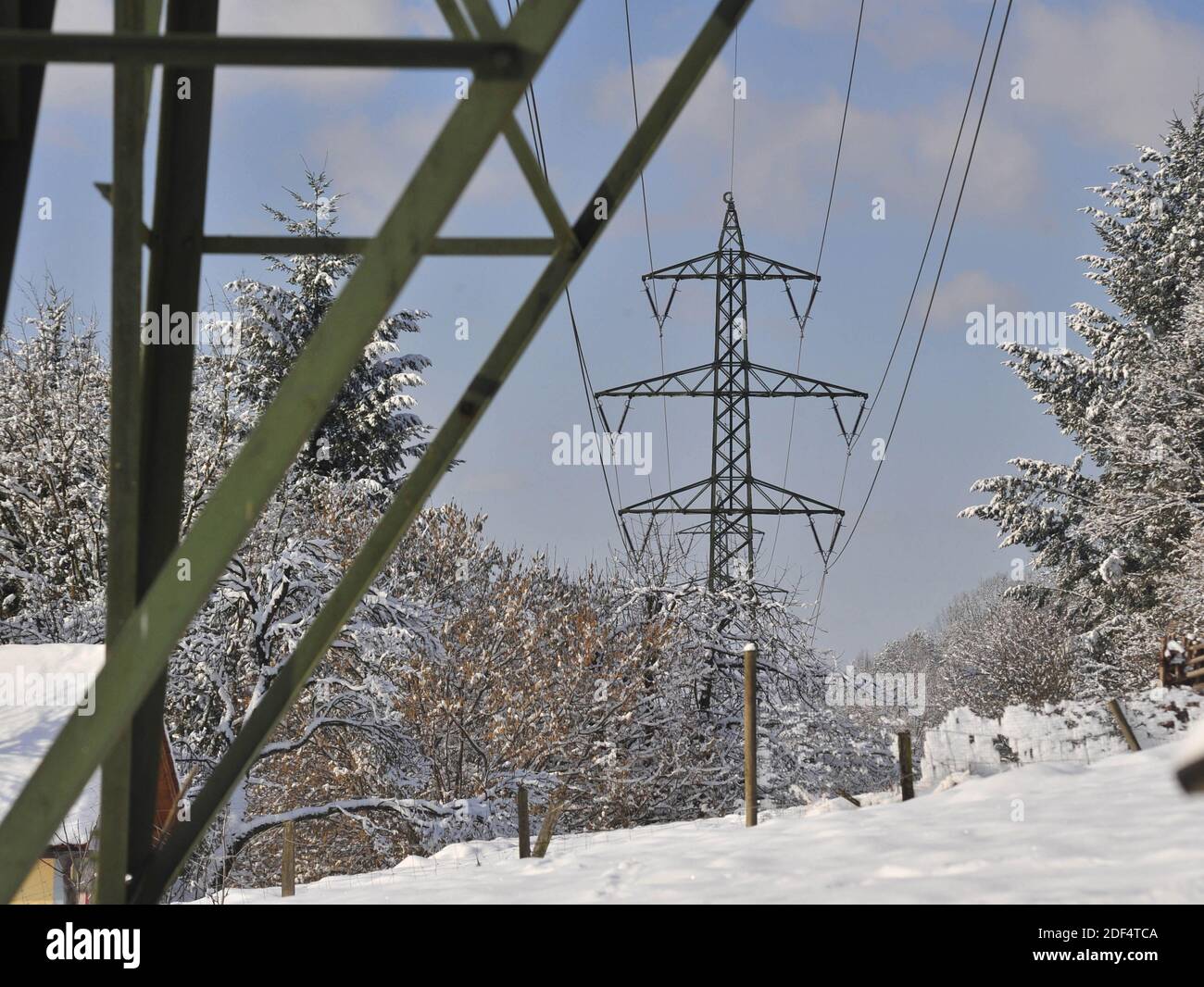 Hochspannungsleitung in den alpen im Winter, verschneite Landschaft Stockfoto