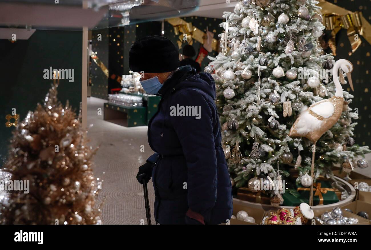 London, Großbritannien. Dezember 2020. Eine Frau mit Gesichtsmaske ist am 2. Dezember 2020 in Harrods in London, Großbritannien, neben einem Weihnachtsbaum zu sehen. Da die COVID-19-Sperre in England am Mittwoch endete, konnten die Menschen einige ihrer üblichen Aktivitäten unter einem neuen Tier-System von Coronavirus-Beschränkungen wieder aufnehmen, das England in Gebiete mit unterschiedlichen restriktiven Maßnahmen aufteilt. Quelle: Han Yan/Xinhua/Alamy Live News Stockfoto