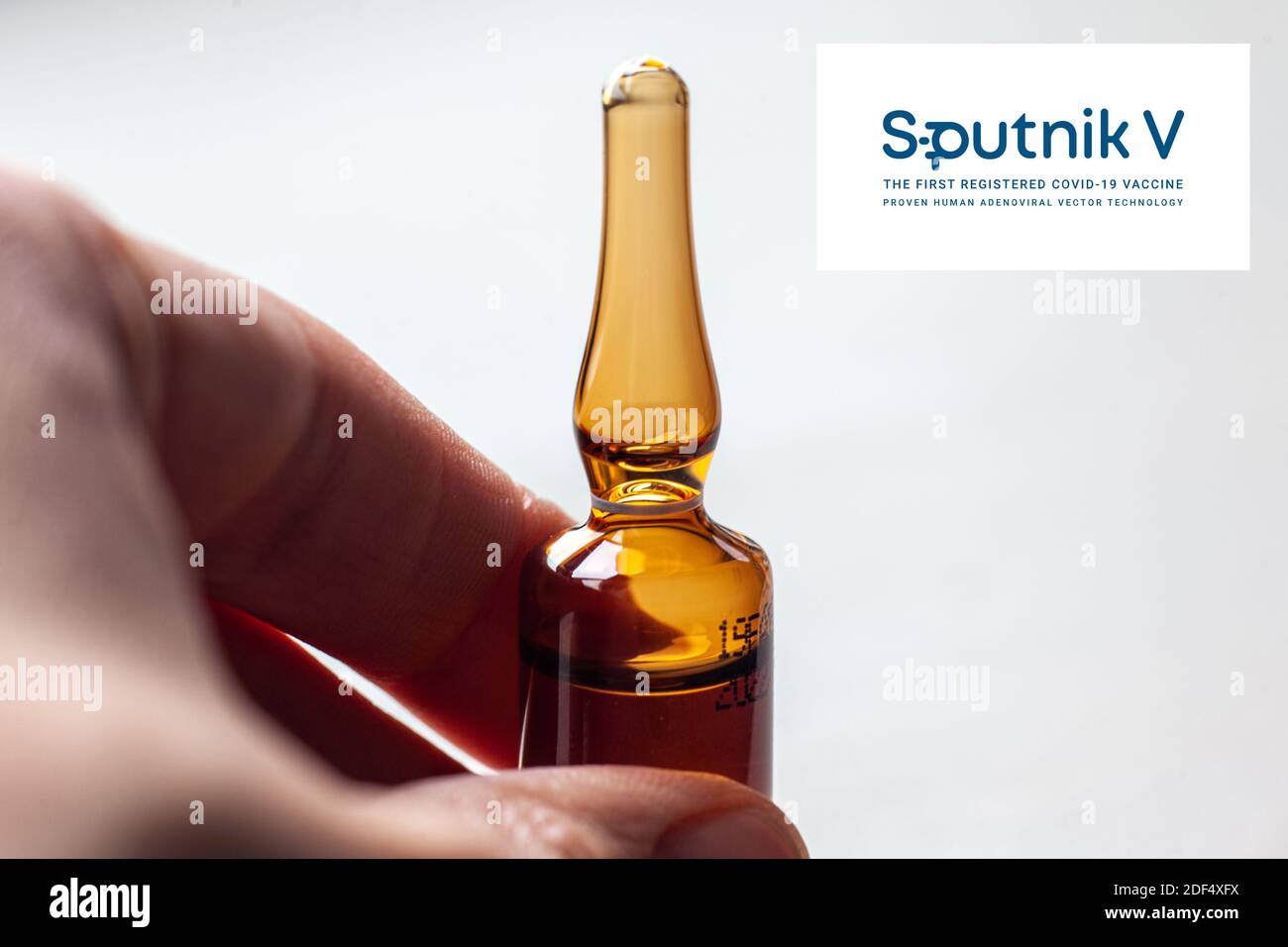 Sputnik Russian Coronavirus Vaccine Pharmaceutical Corporation. Sputnik V Logo mit Hand hält neuen Impfstoff. Stockfoto
