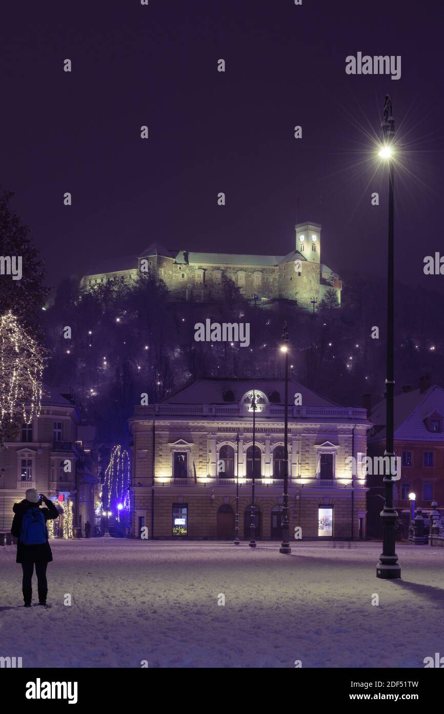 Ljubljana, Slowenien - 2. Dezember 2020: Slowenische Philharmonie und Burg von Ljubljana vom Kongressplatz in Ljubljana, Slowenien am 2. Dezember 2020. Stockfoto