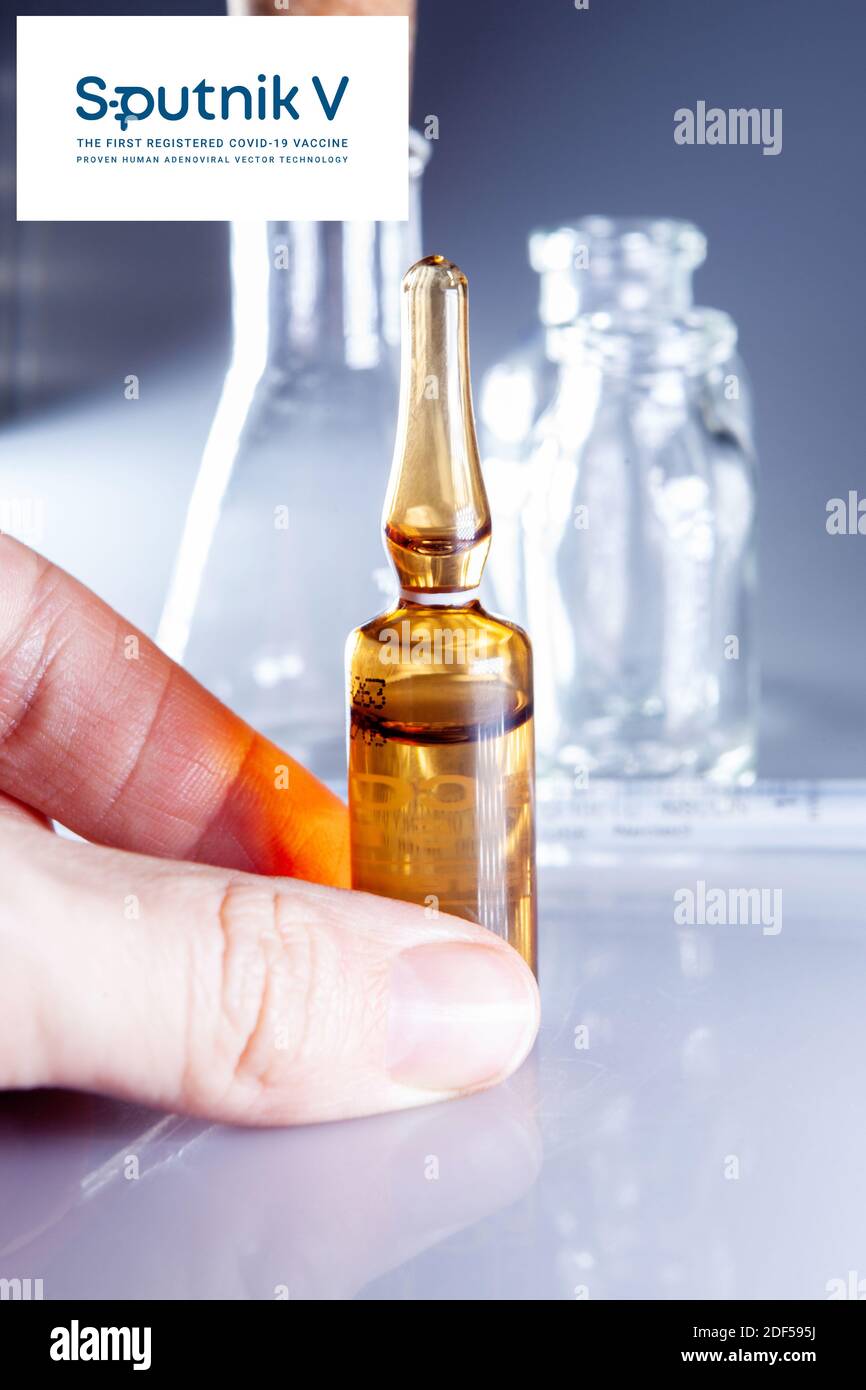 Sputnik Russian Coronavirus Vaccine Pharmaceutical Corporation. Sputnik V Logo mit Hand hält neuen Impfstoff. Stockfoto
