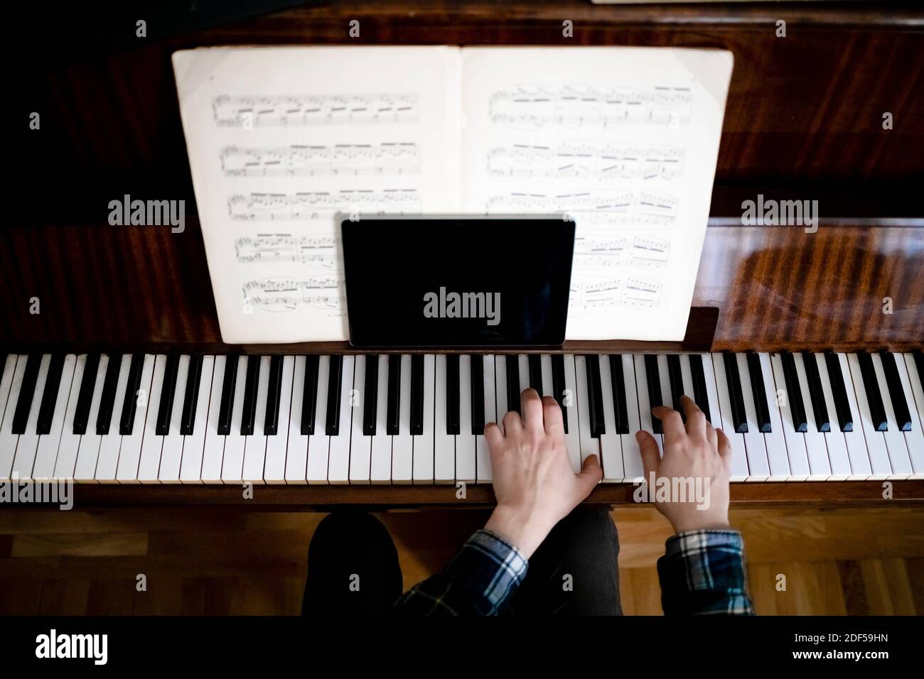 Lehrer spielen Klavier während Online-Unterricht mit einem Tablet zu Kommunizieren Sie mit seinen Schülern Stockfoto
