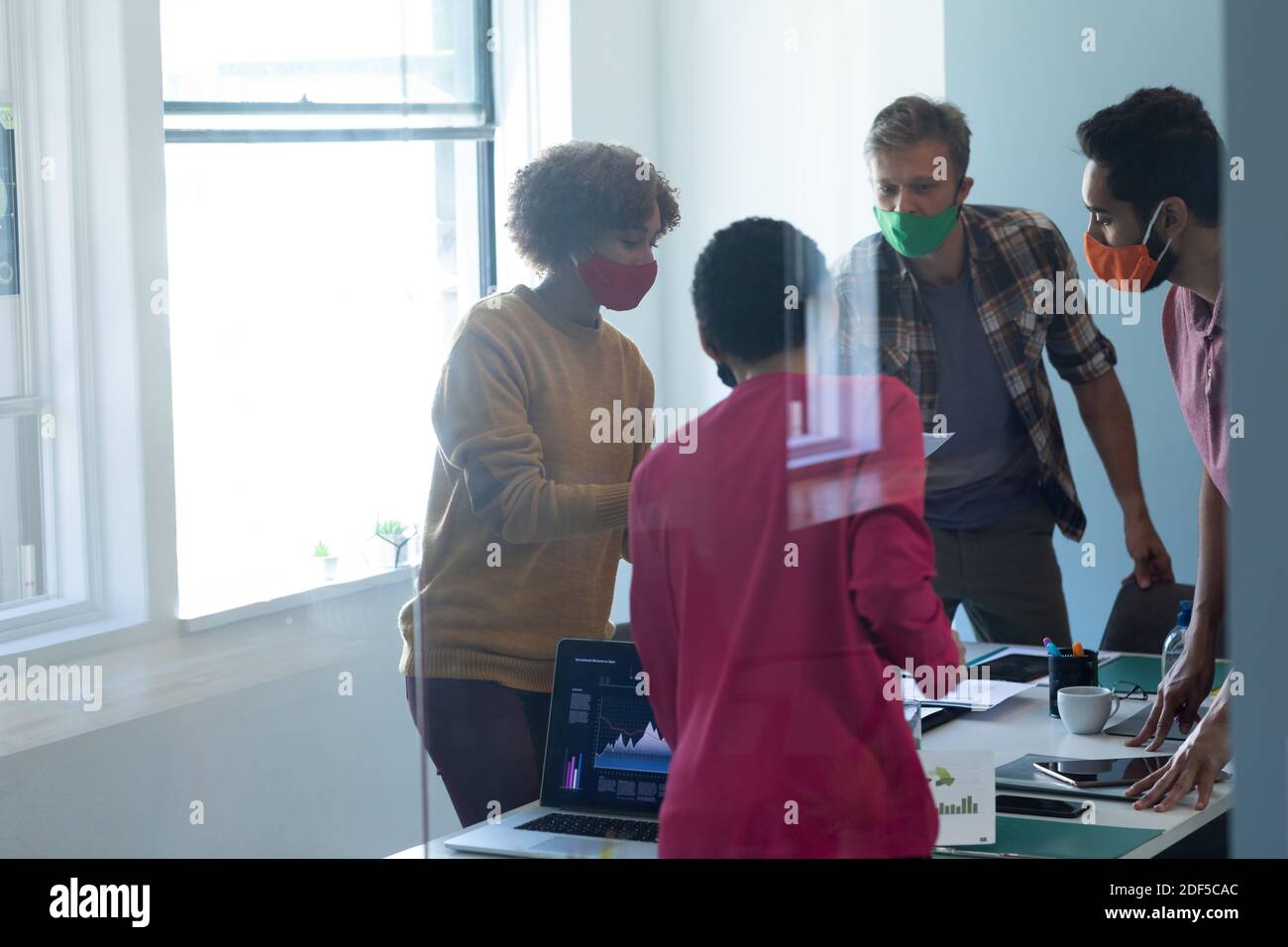 Eine vielfältige Gruppe von Arbeitskollegen, die in einem Büro Masken tragen Stockfoto