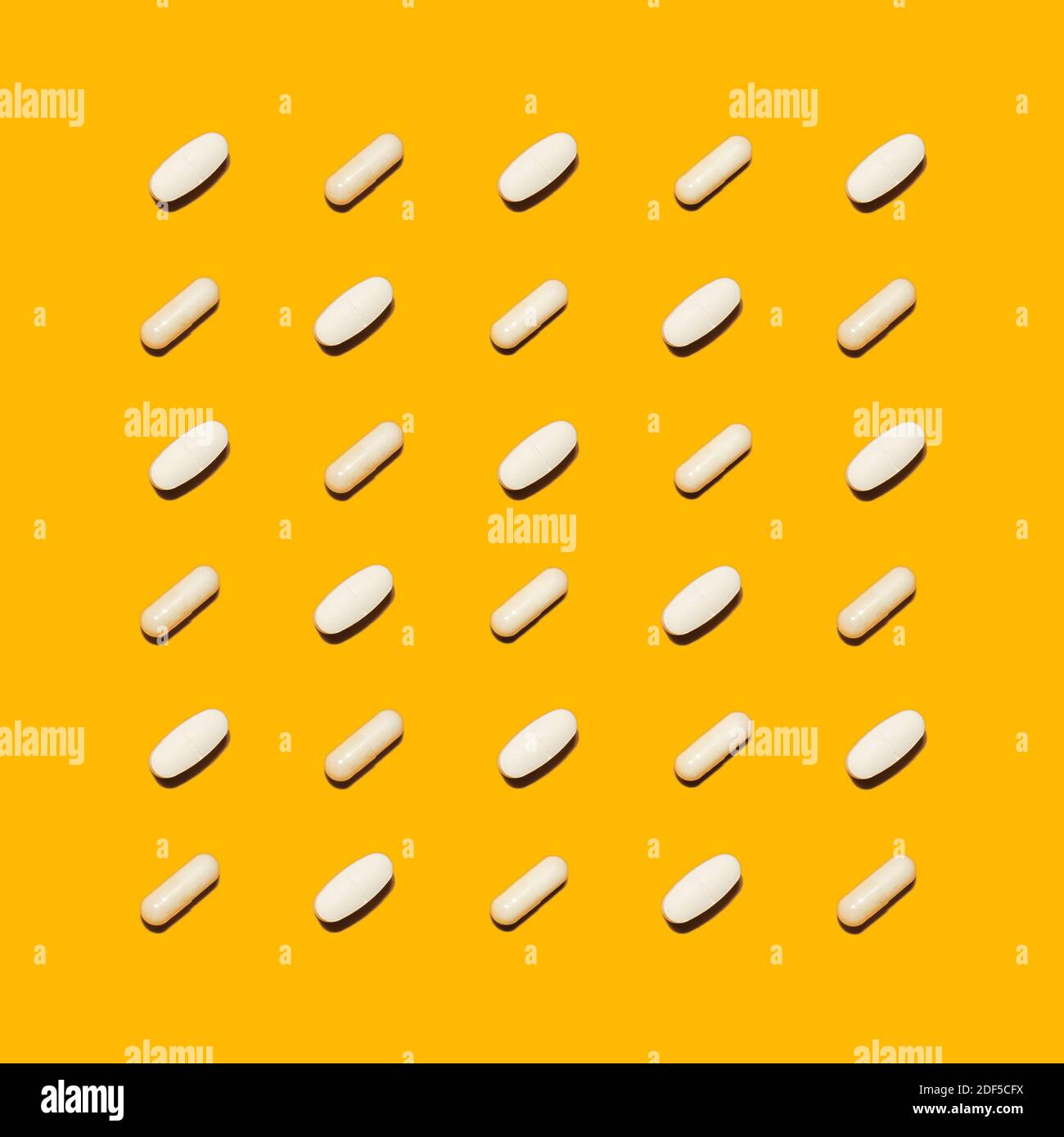 Verschiedene pharmazeutische weiße Medizin Pillen, Tabletten und Kapseln auf hellem gelben Hintergrund. Medizin kreative Konzepte. Flache Lay-Ansicht von oben Stockfoto