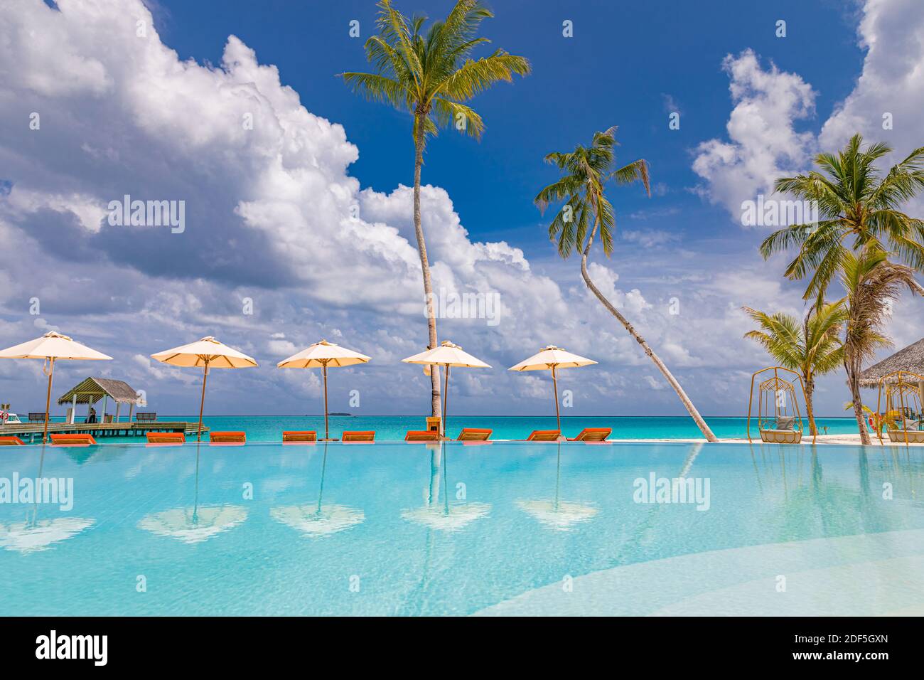 Sommer Strand Swimmingpool an sonnigen Tag mit Spiegelung von Palmen, tropische Landschaft, exotische Insel Hotel Resort Konzept. Luxuriöser Infinity-Pool Stockfoto