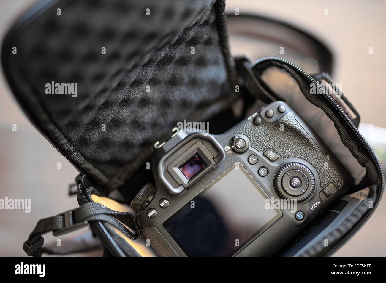 Draufsicht auf den Fotografen mit Digitalkamera in Kameratasche, Blitz, Ladegerät, Reinigungsset, Stativ, Speicherkarte und Kamerazubehör Stockfoto