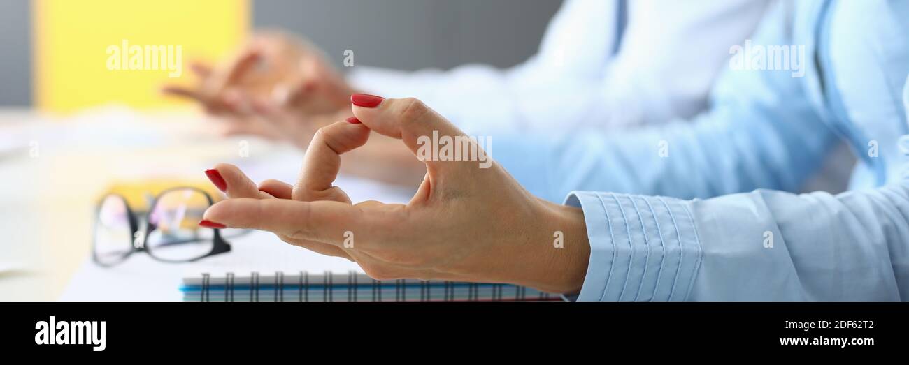 Weibliche und männliche Hände sind in Yoga-Fingern für die Meditation am Tisch im Büro verbunden. Stockfoto