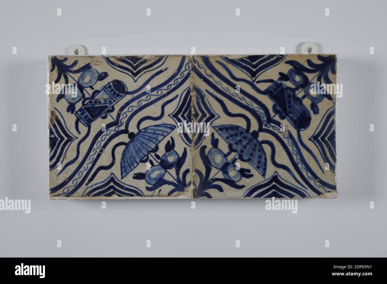 fliesenfeld, Anonymous, erste Hälfte 17. Jahrhundert, Zinn-Glasur, Steingut, mit Rahmen: 13.5 x 26.6 x 3,4 cm (135 x 266 x 34mm), Fliesen: 13.2 x 13.2 x 1,4cm (132 x 132 x 14mm), nordniederland, Fliesenfeld aus zwei Fliesen (eins nach dem anderen) aus Steingut mit Zinn Glasur in blau lackiert bedeckt. Auf dem Fliesenfeld ist ein Chinoiserie-Dekor in einer Diagonale von zwei chinesischen Glückzeichen, einem Sonnenschirm und einer Schreibrolle dargestellt, die durch eine Klammer getrennt sind. Die Fliesen haben als Randmotiv einen halb gefrästen, ineinandergreifenden Ring, 1985 Stockfoto