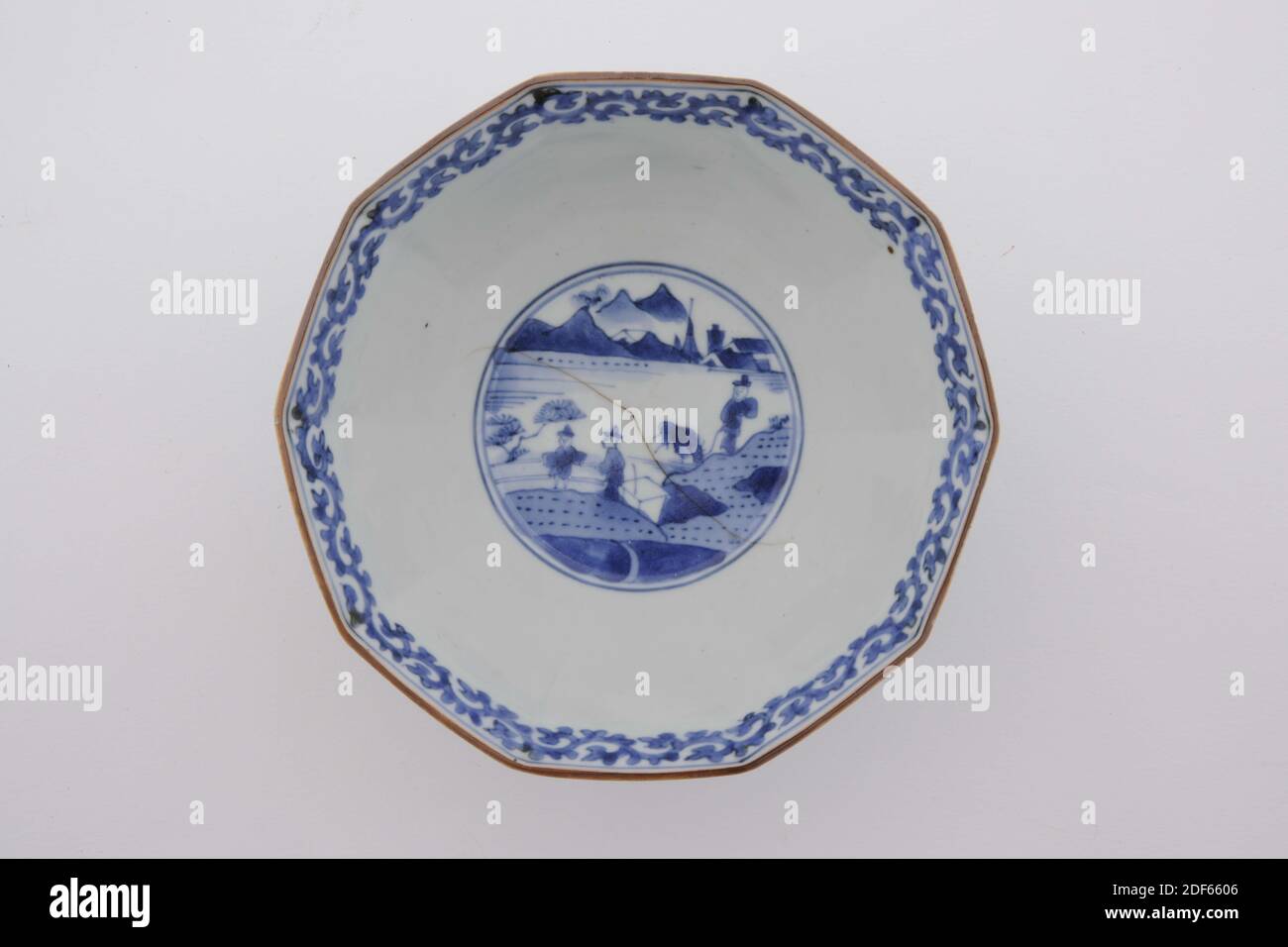 Schüssel, Anonym, Anfang des 18. Jahrhunderts, Porzellan, Emaille, Allgemein: 7.5 x 16 x 16cm (75 x 160 x 160mm), Blume, Landschaft, Frau, Mann, zehnseitige Schale aus japanischem Porzellan auf einem hohen Stand. Dekoriert in Unterglasur blau mit zwei Fächern auf der Außenseite mit vier Blumen und blühenden Pflanzen, und zwei Fächer mit zwei japanischen Damen. In der Mitte drei Männer in der Landschaft, und karakusa Zweig entlang der Kante des Mundes. Unten markiert, 1975 Stockfoto