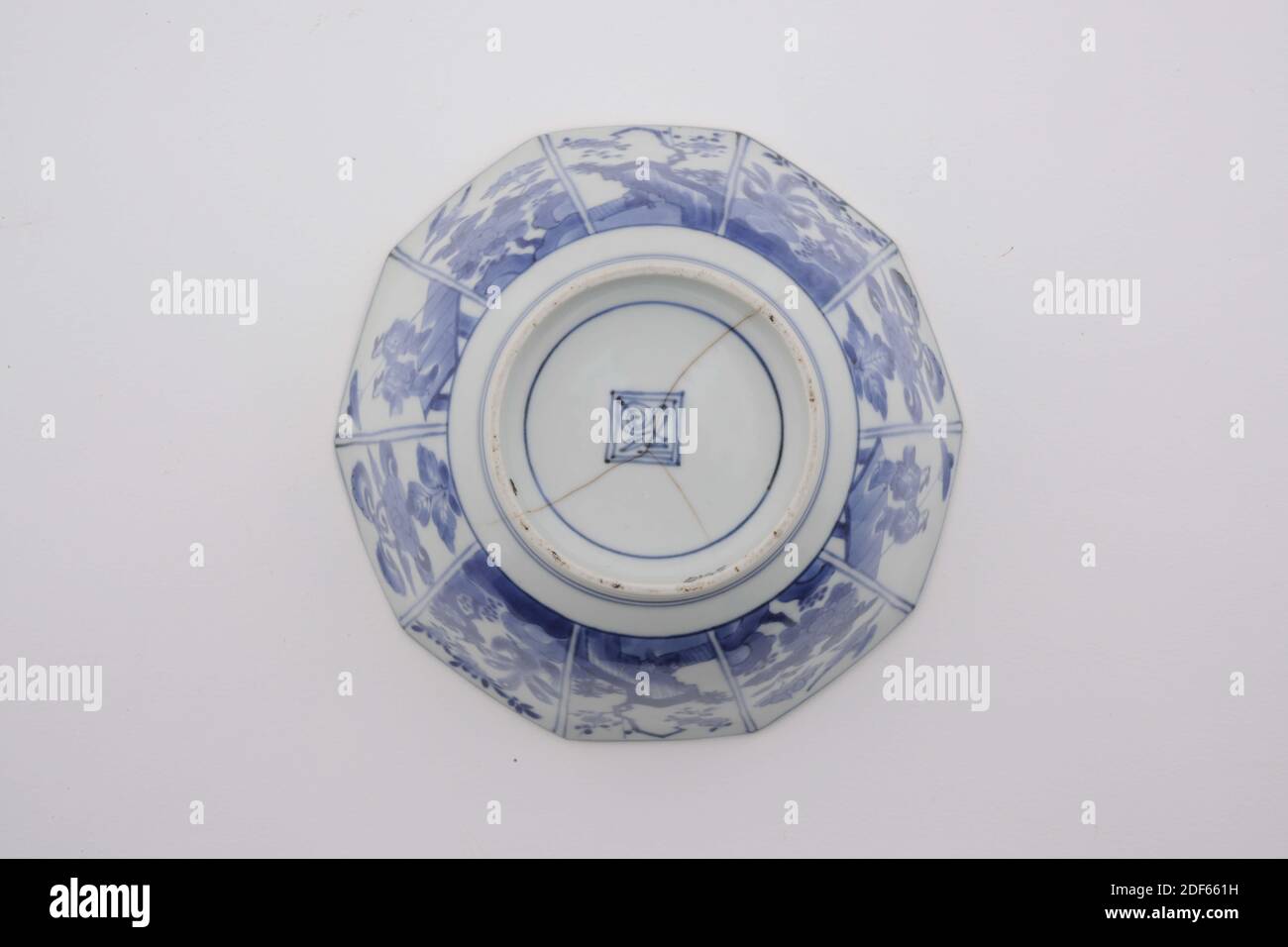 Schüssel, Anonym, Anfang des 18. Jahrhunderts, Porzellan, Emaille, Allgemein: 7.5 x 16 x 16cm (75 x 160 x 160mm), Blume, Landschaft, Frau, Mann, zehnseitige Schale aus japanischem Porzellan auf einem hohen Stand. Dekoriert in Unterglasur blau mit zwei Fächern auf der Außenseite mit vier Blumen und blühenden Pflanzen, und zwei Fächer mit zwei japanischen Damen. In der Mitte drei Männer in der Landschaft, und karakusa Zweig entlang der Kante des Mundes. Unten markiert, 1975 Stockfoto