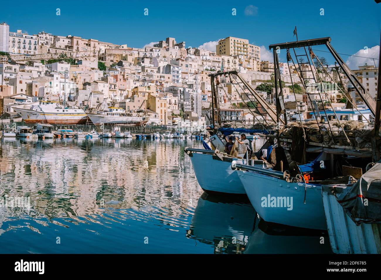 Sciacca Sizilien Oktober 2020, Fischerboote und Menschen reparieren Netze in der bunten Stadt Sciacca mit Blick auf ihren Hafen. Provinz Agrigento, Sizilien. Hochwertige Fotos Stockfoto