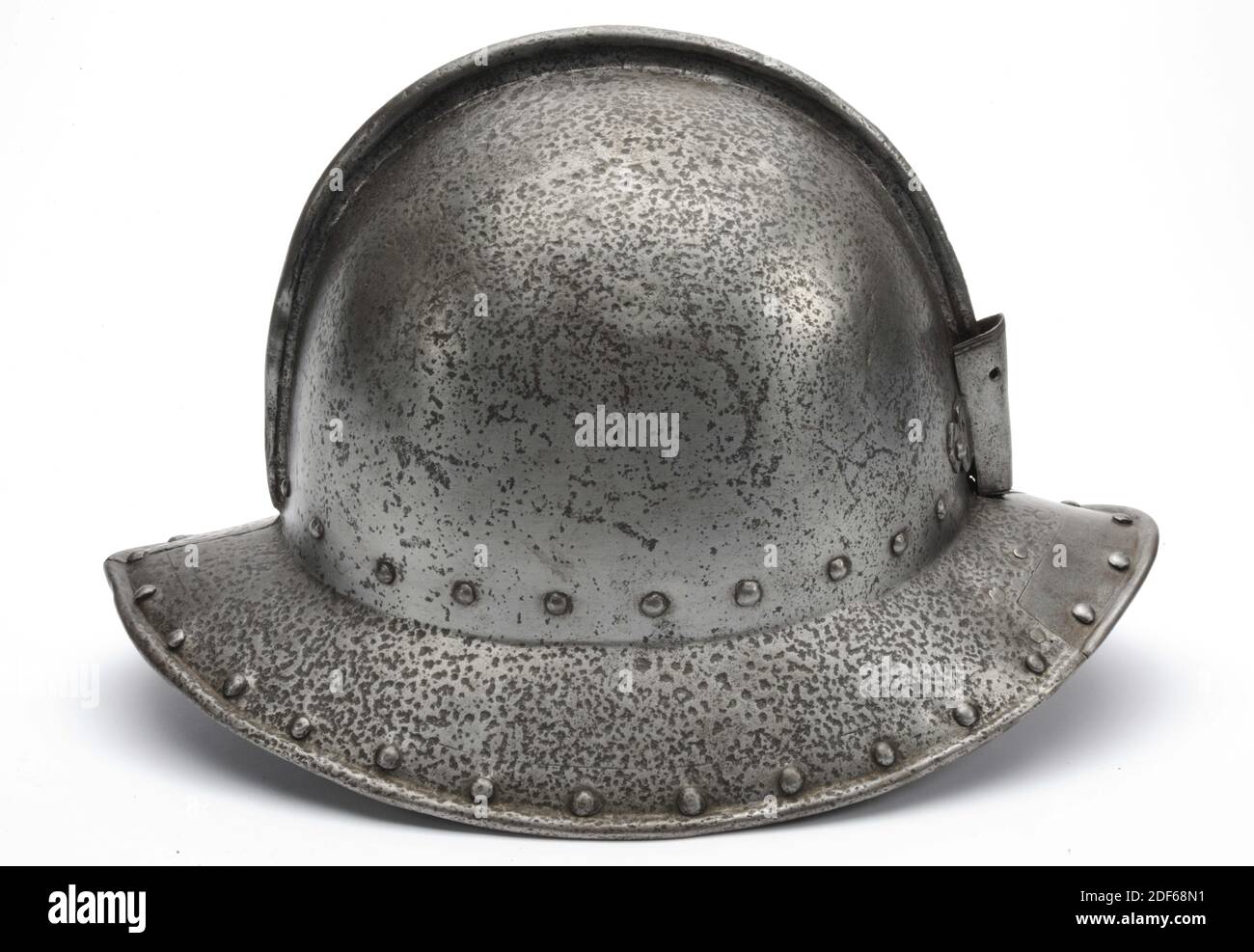 Helm, Anonymous, 16. Jahrhundert, Iron Cabasset mit einer eisernen Federhülse und Helmwappen. Der Helm ist oval geformt und hat eine hohe, kugelförmige Helmkugel, die Helmklappe ist nach unten geneigt. Die Helmkugel besteht aus zwei Hälften und ist über dem Kamm mit einem gefalteten Streifen aus Eisen fertig. An der hinteren Spitze des Helmvisiers ist ein Teil der Platte ein zeitgemäßer Ersatz, und so ist ein Stück der angrenzenden Felge. Auch der Frontpunkt wurde ersetzt und zu der Zeit auch mit neuen Nieten versehen, die anschließend außen oder oben abgefeilt wurden. Futter Nägel um den Rand der Stockfoto