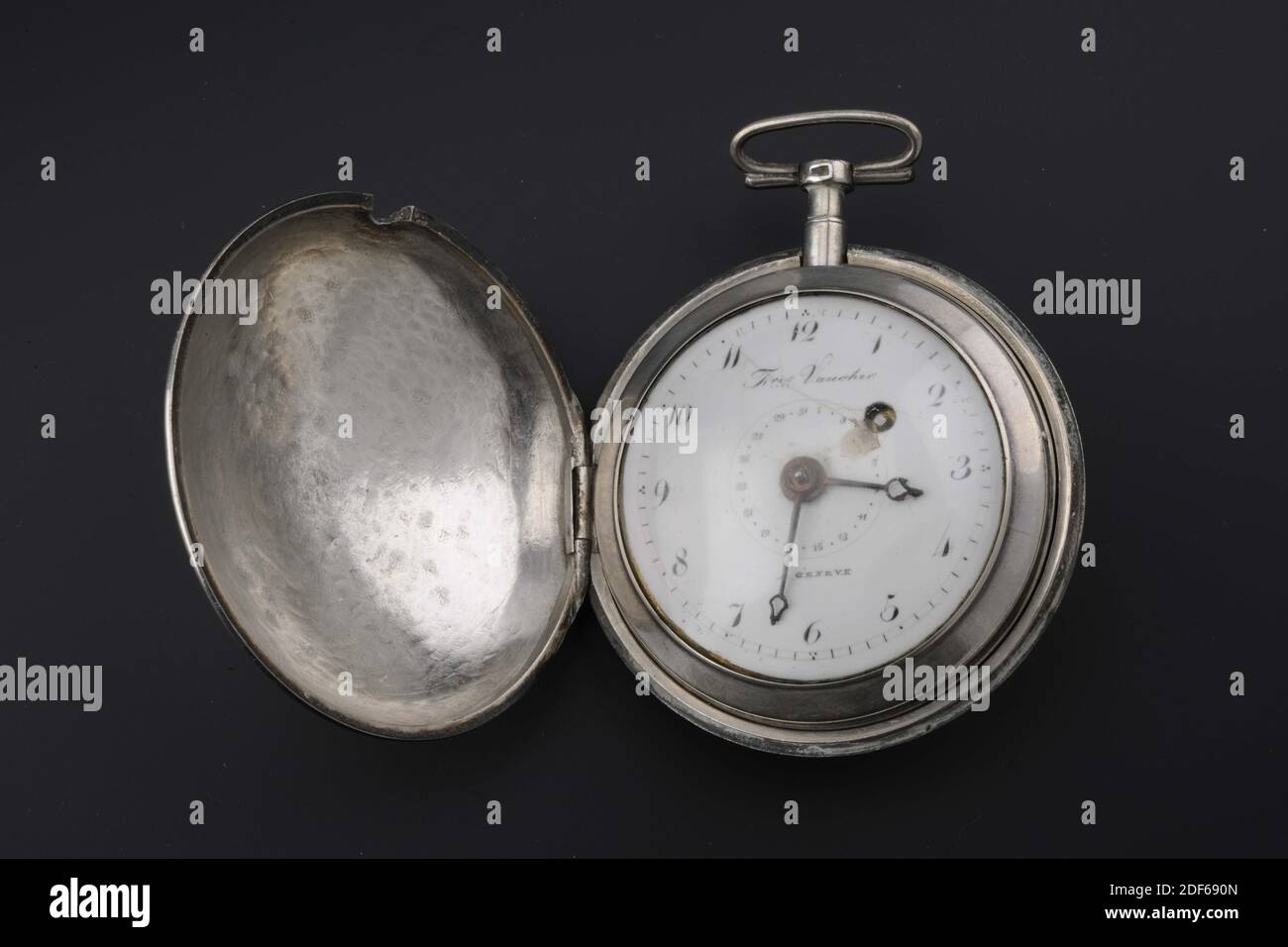 Uhr, F.res. Vaucher, 1811?, Glas, Silber, Silber Uhr in einem losen Halter.  Die Uhr hat ein weißes, rundes Zifferblatt hinter Glas. Auf dem  Zifferblatt, am äußeren Rand, die Zahlen (Arabisch) eins bis