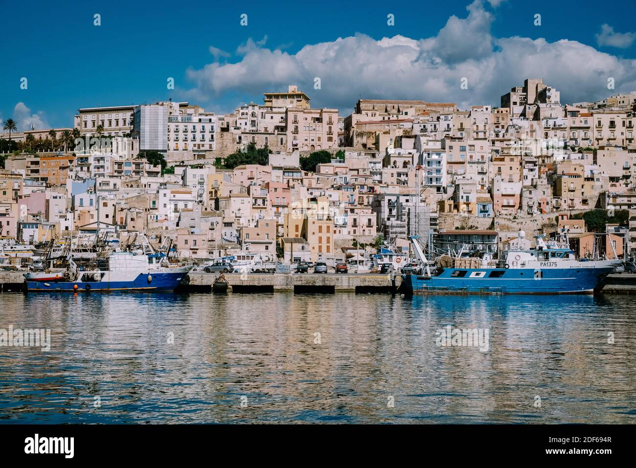 Sciacca Sizilien Oktober 2020, Fischerboote und Menschen reparieren Netze in der bunten Stadt Sciacca mit Blick auf ihren Hafen. Provinz Agrigento, Sizilien. Hochwertige Fotos Stockfoto