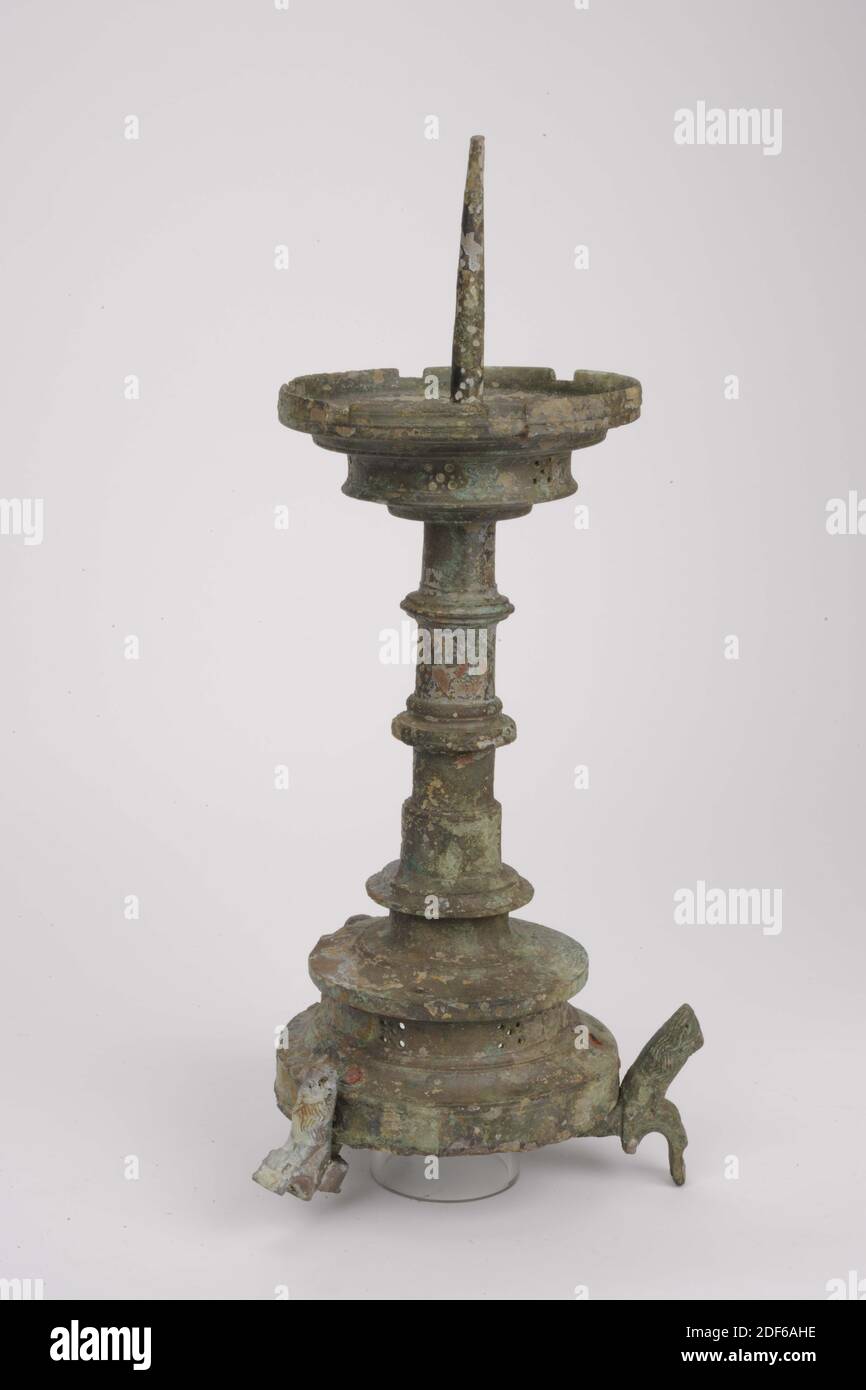 Candlestick, Anonymous, ca. 1450, gegossen, Allgemein: 47 x 16cm 470 x 160mm, Löwe, der Kerzenständer ruht auf drei Löwen, die an drei genieteten Nocken befestigt sind. Die gewölbte Basis hat eine fünfstufige Dekoration im vertikalen Hohlrahmen. Der Fuß endet in einer stark hervorstehenden Kante. Es gibt einen profilierten, ringförmigen Knoten um eine Verdickung an der Unterseite der Welle. Darüber ist er leicht zulaufend und hat dort noch zwei Knoten. Sie endet in der profilierten Fettfalle mit sechs Neigungen und mit sechs fünf Schritten in der vertikalen Kante. Die Innenseite der Fettabscheider fällt Schritt für Schritt nach unten Stockfoto
