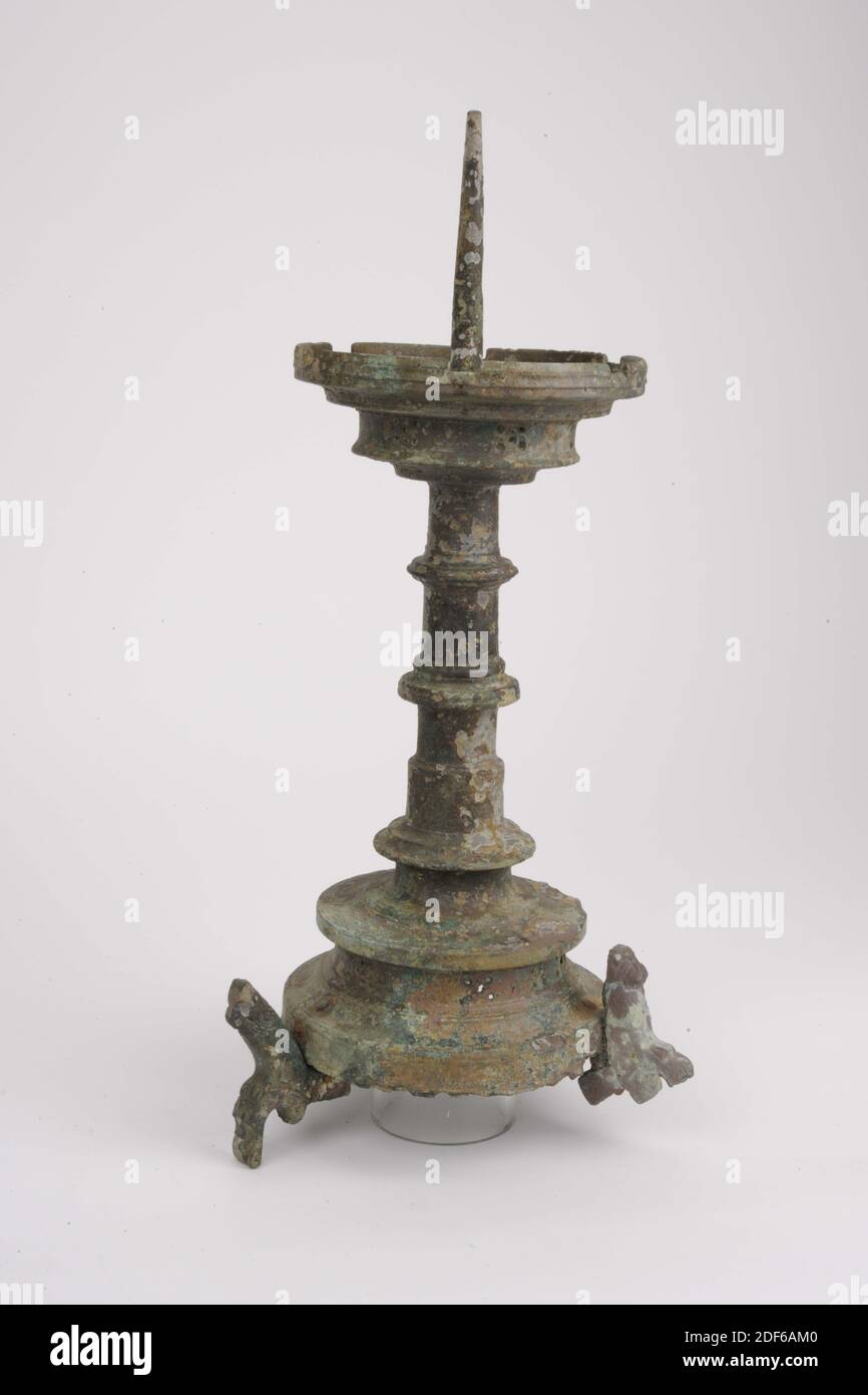 Candlestick, Anonymous, ca. 1450, gegossen, Allgemein: 47 x 16cm 470 x 160mm, Löwe, der Kerzenständer ruht auf drei Löwen, die an drei genieteten Nocken befestigt sind. Die gewölbte Basis hat eine fünfstufige Dekoration im vertikalen Hohlrahmen. Der Fuß endet in einer stark hervorstehenden Kante. Es gibt einen profilierten, ringförmigen Knoten um eine Verdickung an der Unterseite der Welle. Darüber ist er leicht zulaufend und hat dort noch zwei Knoten. Sie endet in der profilierten Fettfalle mit sechs Neigungen und mit sechs fünf Schritten in der vertikalen Kante. Die Innenseite der Fettabscheider fällt Schritt für Schritt nach unten Stockfoto