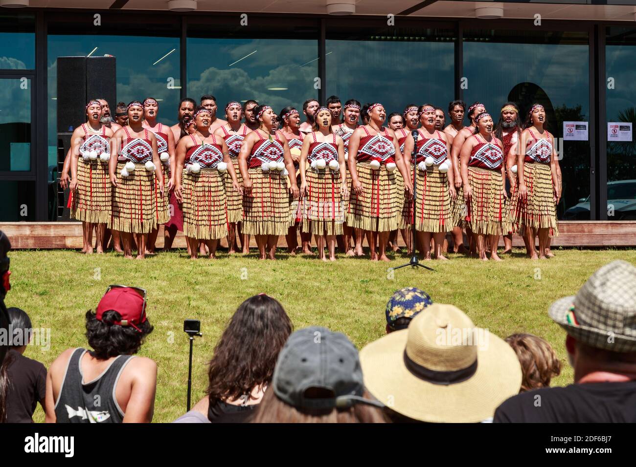 Eine Gruppe von Maori kapa haka (traditioneller Tanz) Interpreten, die vor einer Menschenmenge singen Stockfoto