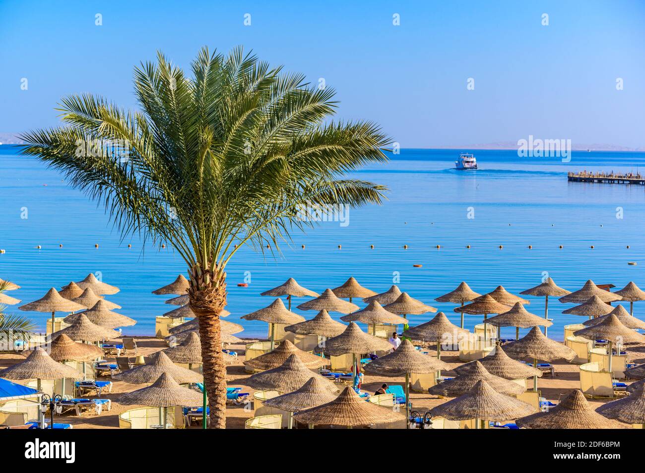 Entspannung am paradiesischen Strand - Chaise Lounge und Sonnenschirme - Reiseziel Hurghada, Ägypten Stockfoto