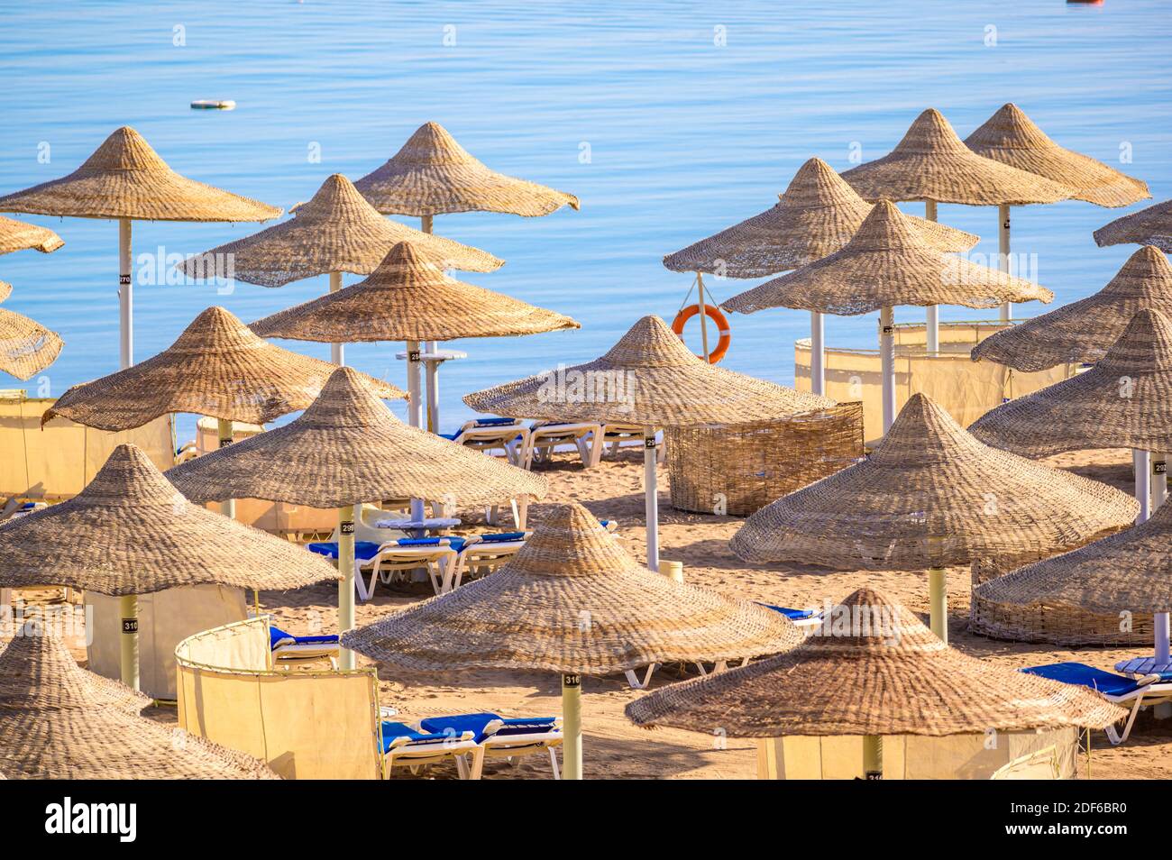 Entspannung am paradiesischen Strand - Chaise Lounge und Sonnenschirme - Reiseziel Hurghada, Ägypten Stockfoto