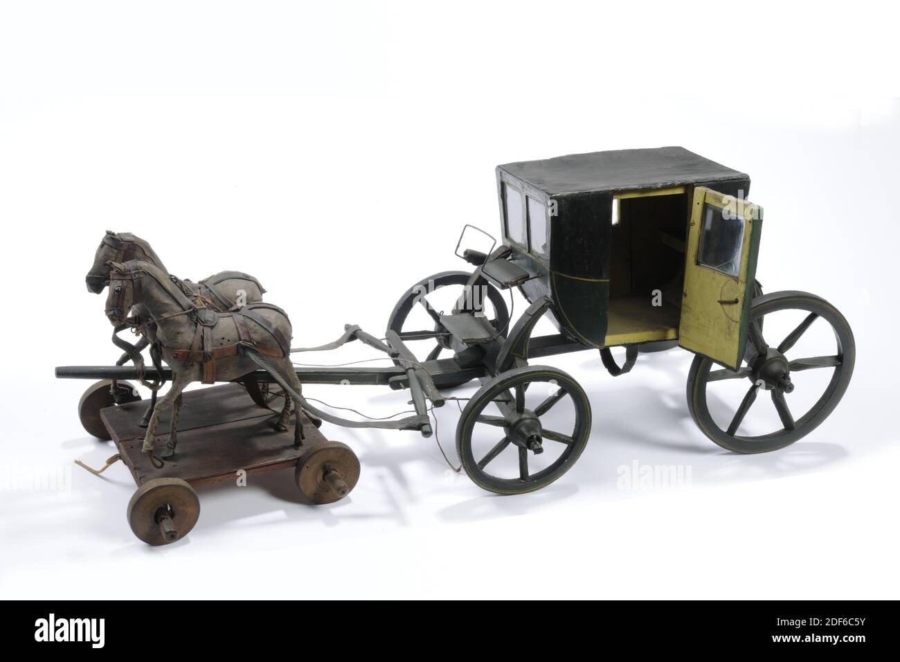 Anonym, erste Hälfte des 19. Jahrhunderts, Glas, Holz, Seil, Leder, bemalt, Spielzeugwagen mit zwei Pferden, ein Paar Pferde, aus bemaltem Holz. Der schwarz-grün lackierte Wagen enthält zwei Vierradachsen, wobei die Hinterräder größer sind als die Vorderräder. Der Bus hat eine überdachte Motorhaube für die Passagiere und einen separaten Sitz für den Kutscher. Beide Türen des Wagens haben C.D.F .. Unter den Glasfenstern. Die Kutsche hat zwei Pferde, mit Leder bedeckt und steht auf einem Plateau mit vier kleinen Rädern. Die Zügel der Pferde sind aus Seil. Die Pferdeschwänze sind abgebrochen, General Stockfoto