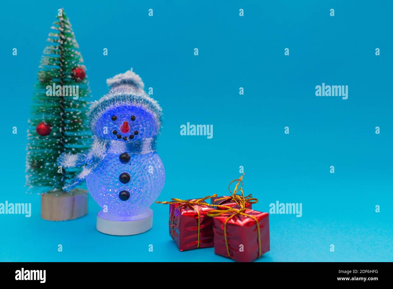 Leuchtet im dunklen Schneemann, Geschenke und Weihnachtsbaum mit Copy Space.Weihnachten und Neujahr Feier. Stockfoto