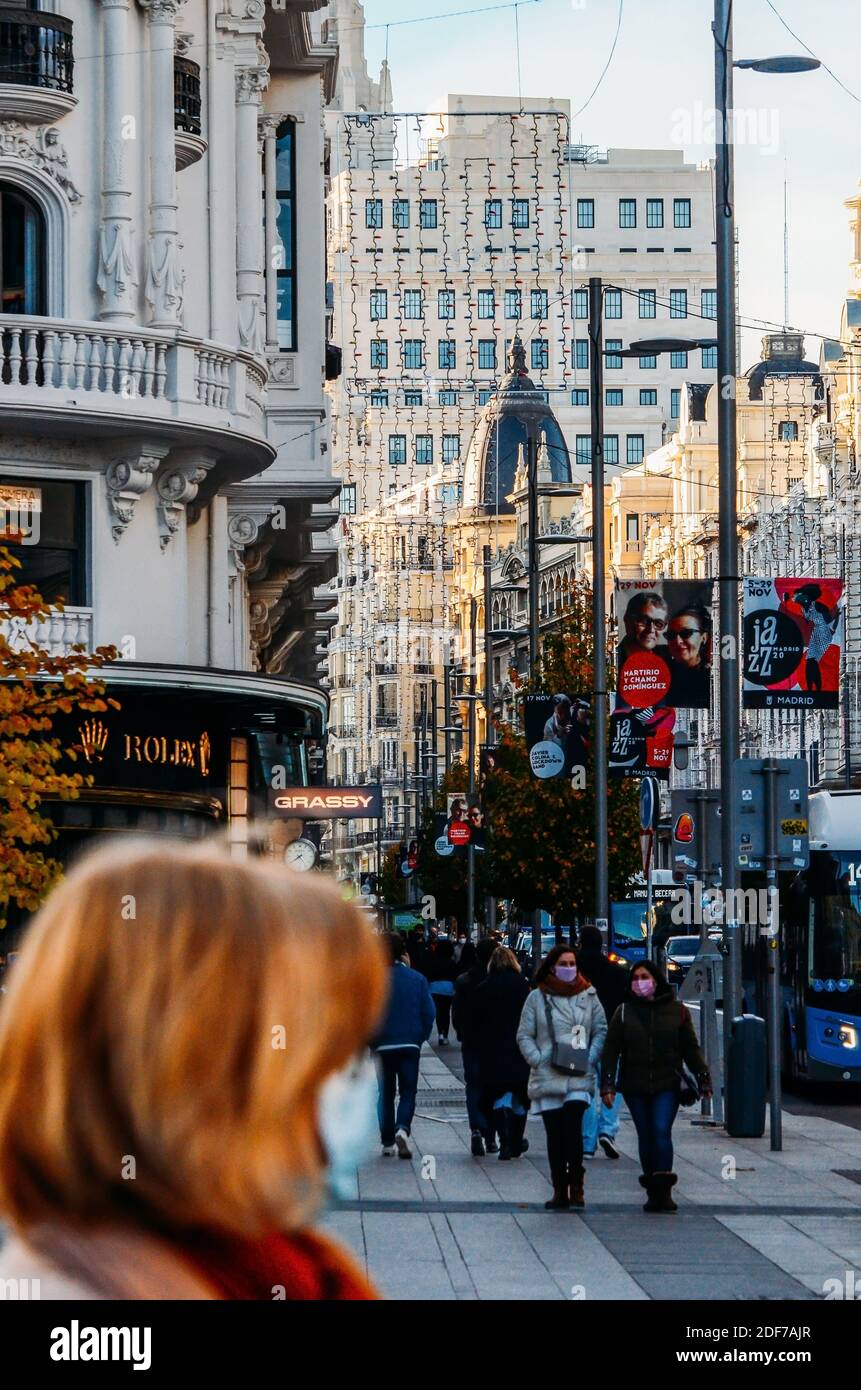 Madrid, Spanien - 29. November 2020: Überfüllte Fußgängerzone in Gran Via, Madrid, Spanien. Die Menschen tragen obligatorische Gesichtsbedeckung während der Covid-19 Stockfoto