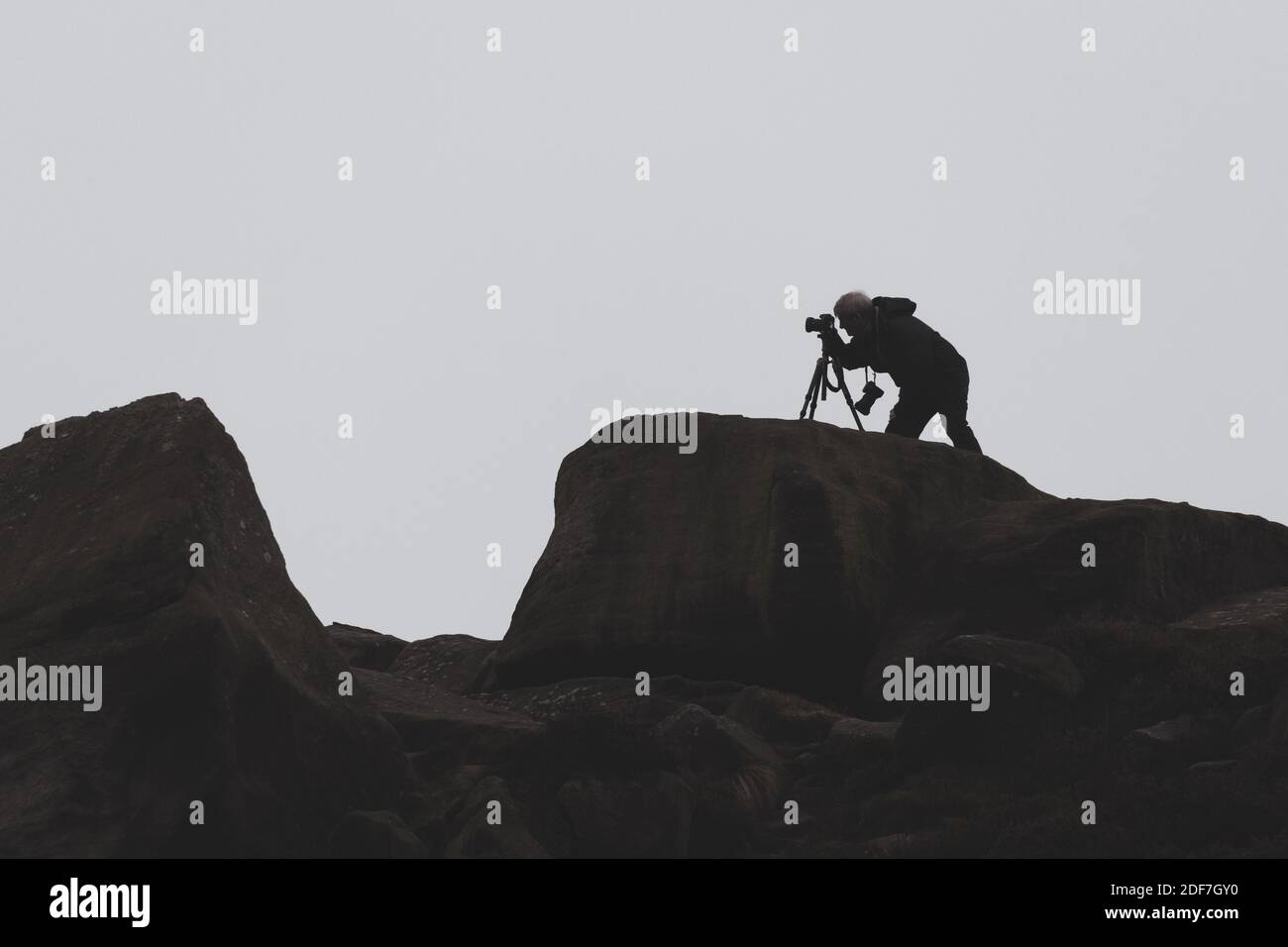 Person auf dem Land, die mit einer Kamera ein Foto macht, während seine andere Kamera auf einem Stativ steht und in die andere Richtung schaut, West Yorkshire Stockfoto