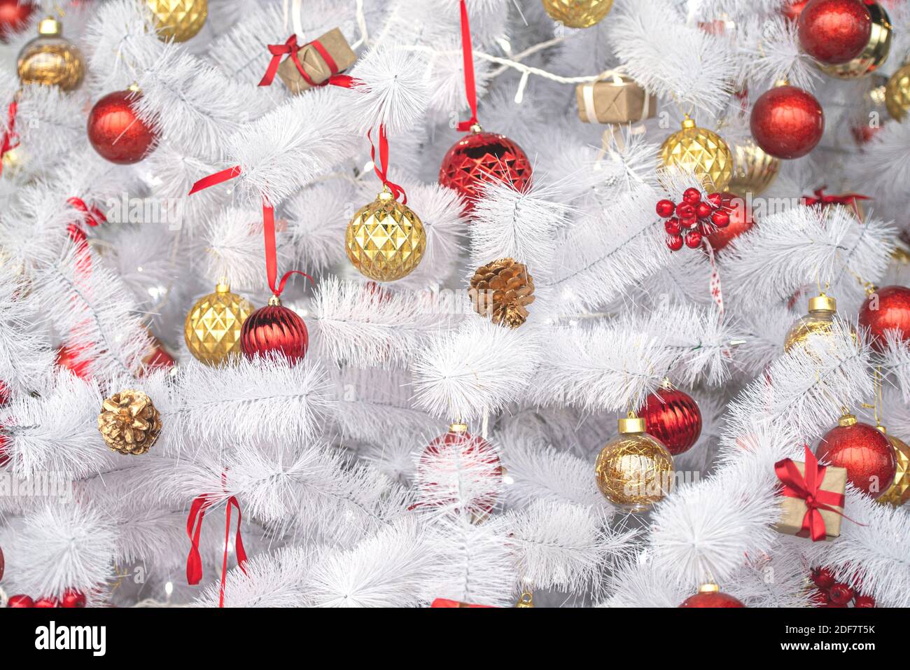 Weißer oder silberner Weihnachtsbaum mit roten, goldenen Spielzeugen, Neujahrskomposition Stockfoto