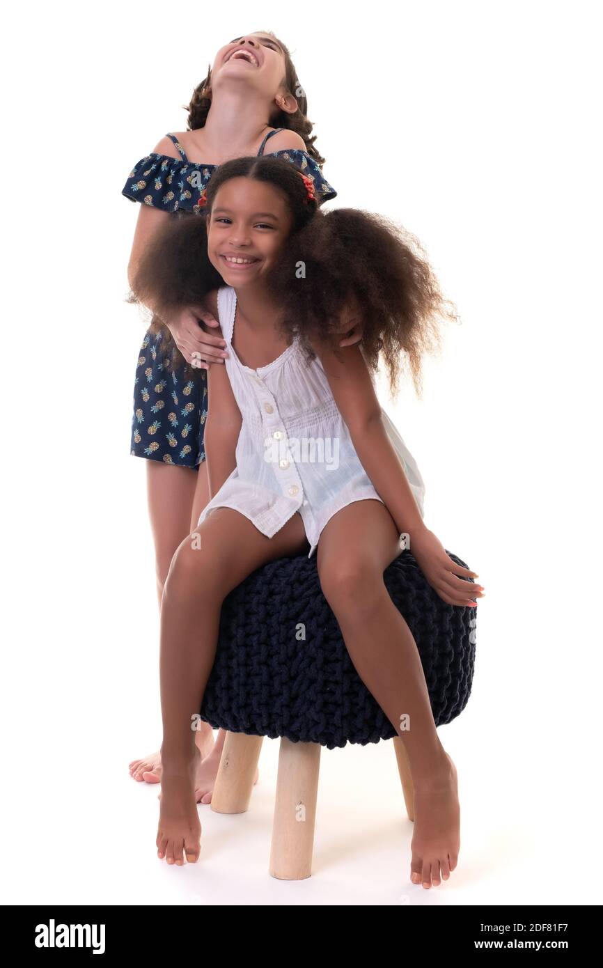 Zwei freundliche kleine Mädchen lachen, Freunde oder Schwestern - Hispanic und afro-american - isoliert auf weiß Stockfoto