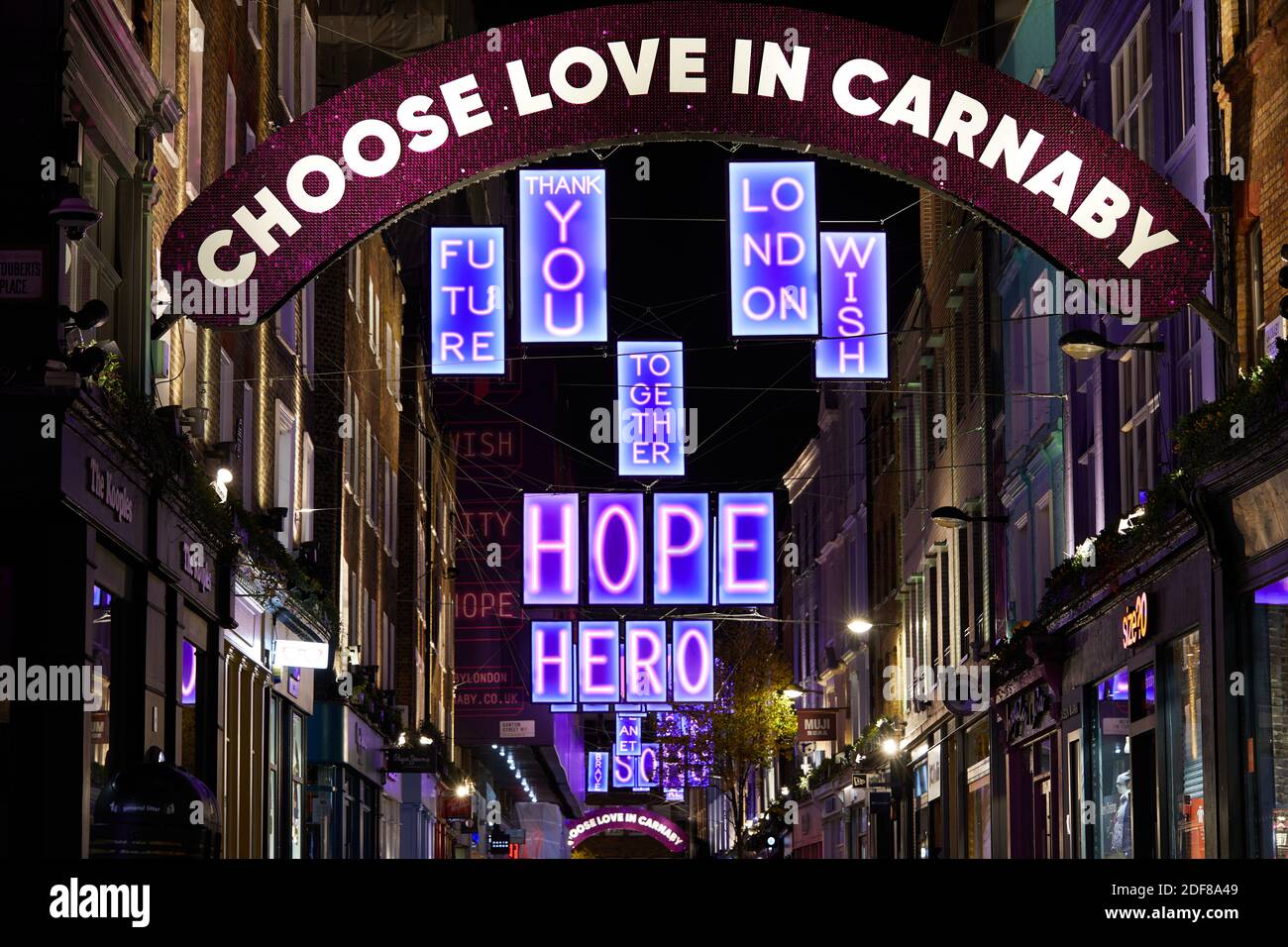 London, Großbritannien. - 2 Dez 2020: Die Carnaby Street 2020 Weihnachtsbeleuchtung, in diesem Jahr in Partnerschaft mit Charity Choose Love, die eine Reihe von Leuchtkästen mit positiven Botschaften sieht. Stockfoto