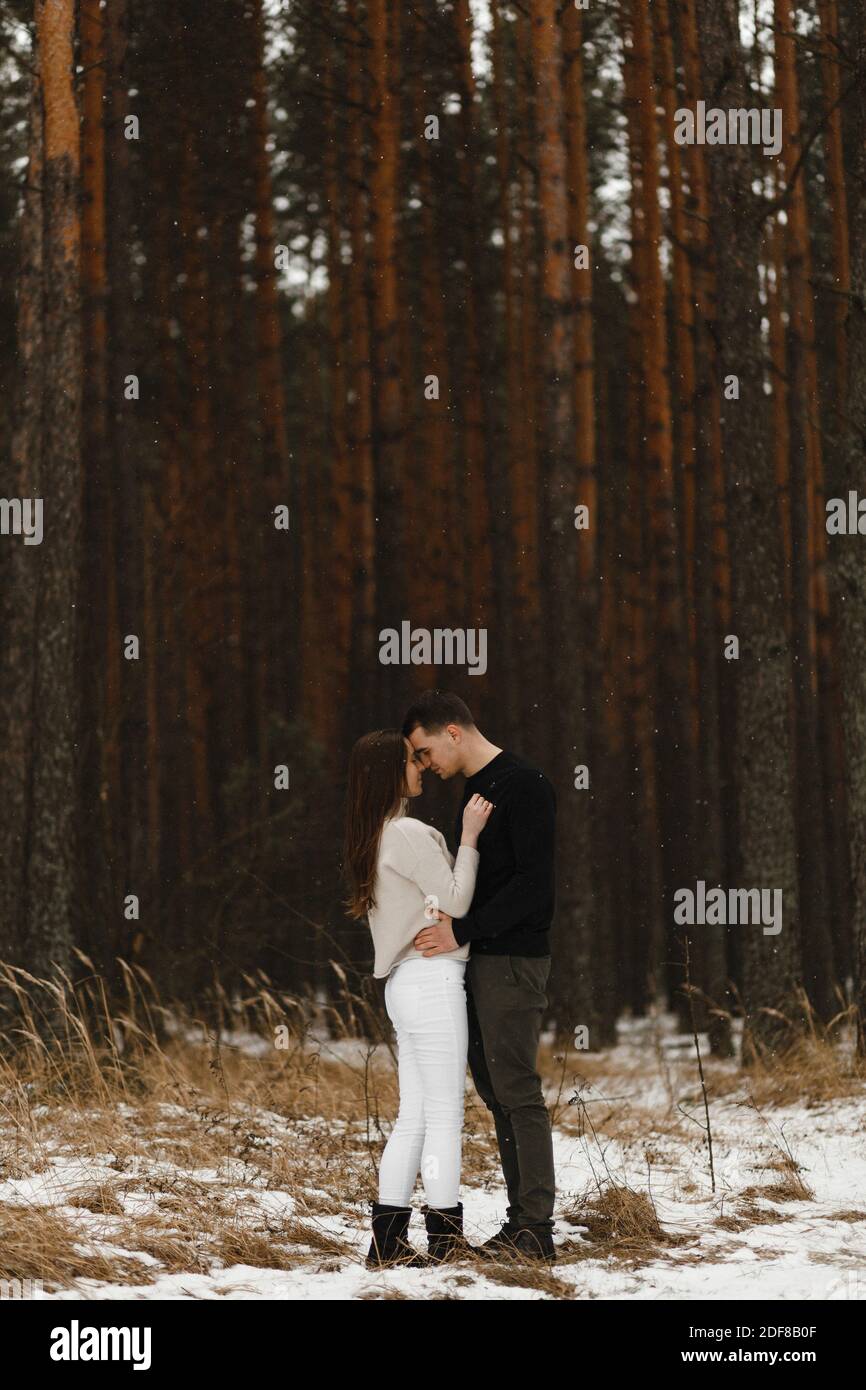Junger Mann und Frau küssen sich im Winterwald. Mit dem Ort für Ihren Text. Liebe, Beziehung, Winterurlaub. Winter paar Foto-Ideen Stockfoto