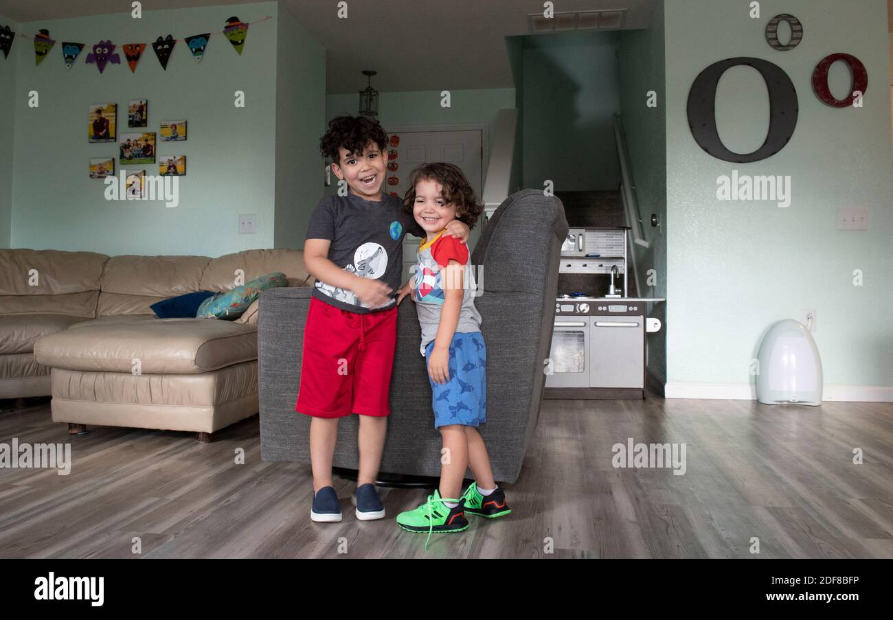 Kafry (6) Overton in roten Shorts, mit seinem Bruder Saben (4) in blauen Shorts im Wohnzimmer ihres Hauses in Süd-Austin. Stockfoto