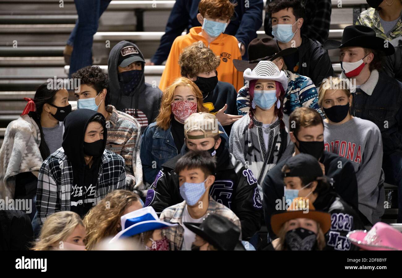 Chilly Cedar Ridge Schüler tragen Masken und huddle in den Ständen bei einem High School Fußballspiel im Dragon Stadium in Round Rock, Texas an einem kalten und windigen Freitagabend während der COVID Pandemie. Die Studenten distanzierten sich nicht sozial. Stockfoto